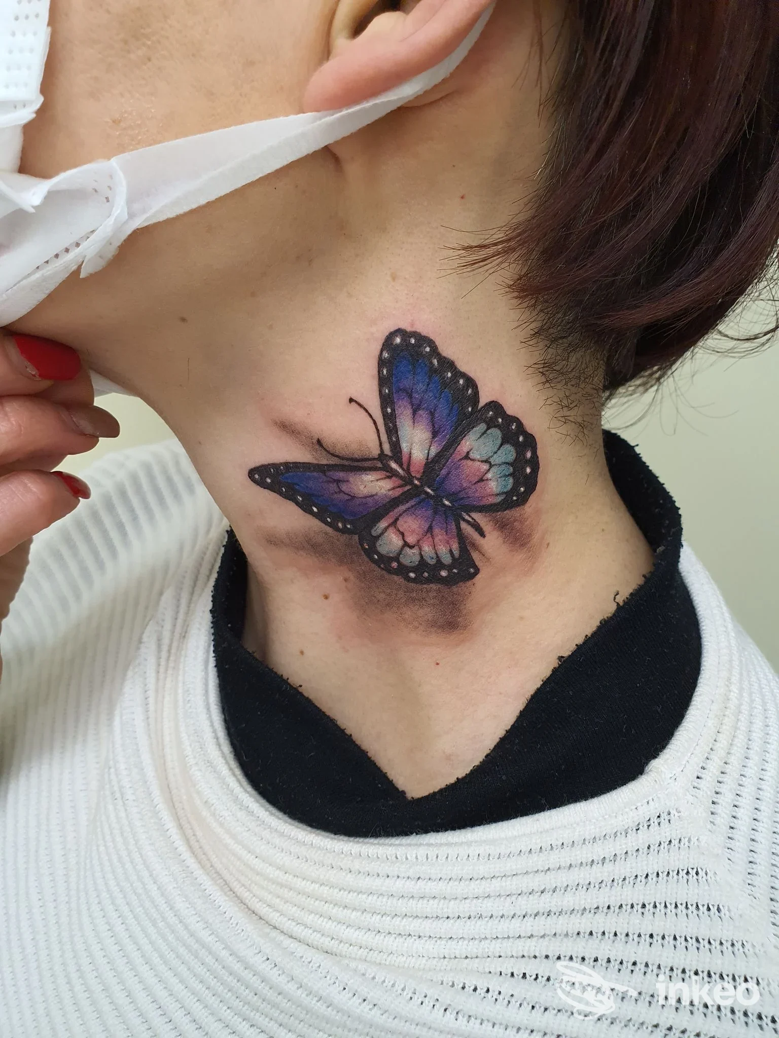Farfalla colorata tatuata sul collo in stile sfumato, fotografia del dettaglio eseguita da Lubens Art a Campobasso.