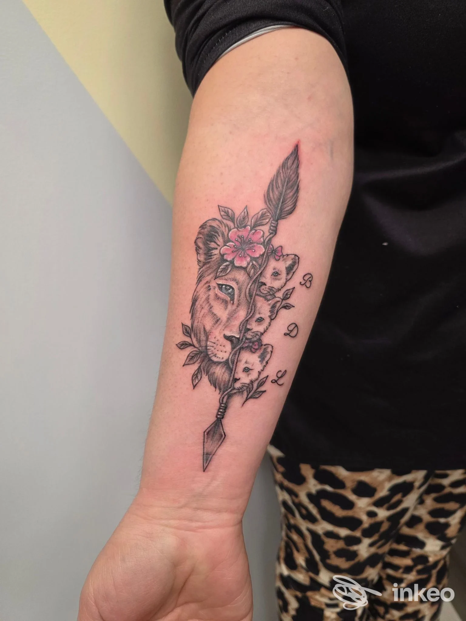 Tatuaggio su avambraccio con mezza testa di leone, fiori e pendente, foto fornita da Lubens Art a Campobasso.