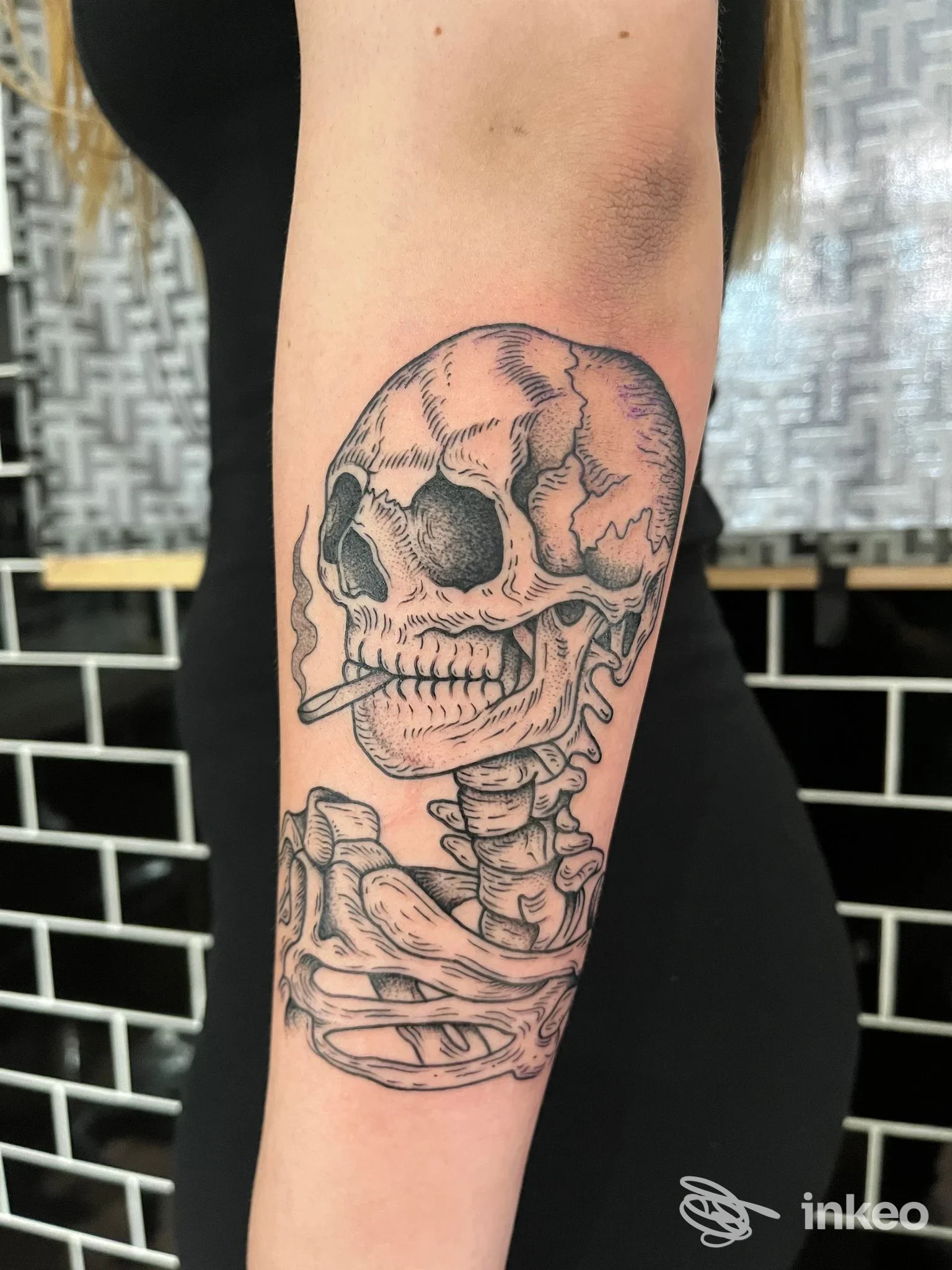 Tatuaggio dettagliato di teschio e colonna sul lato interno dell'avambraccio, fotografato sul corpo del cliente; lavoro eseguito da Angela Smisek a Termoli.