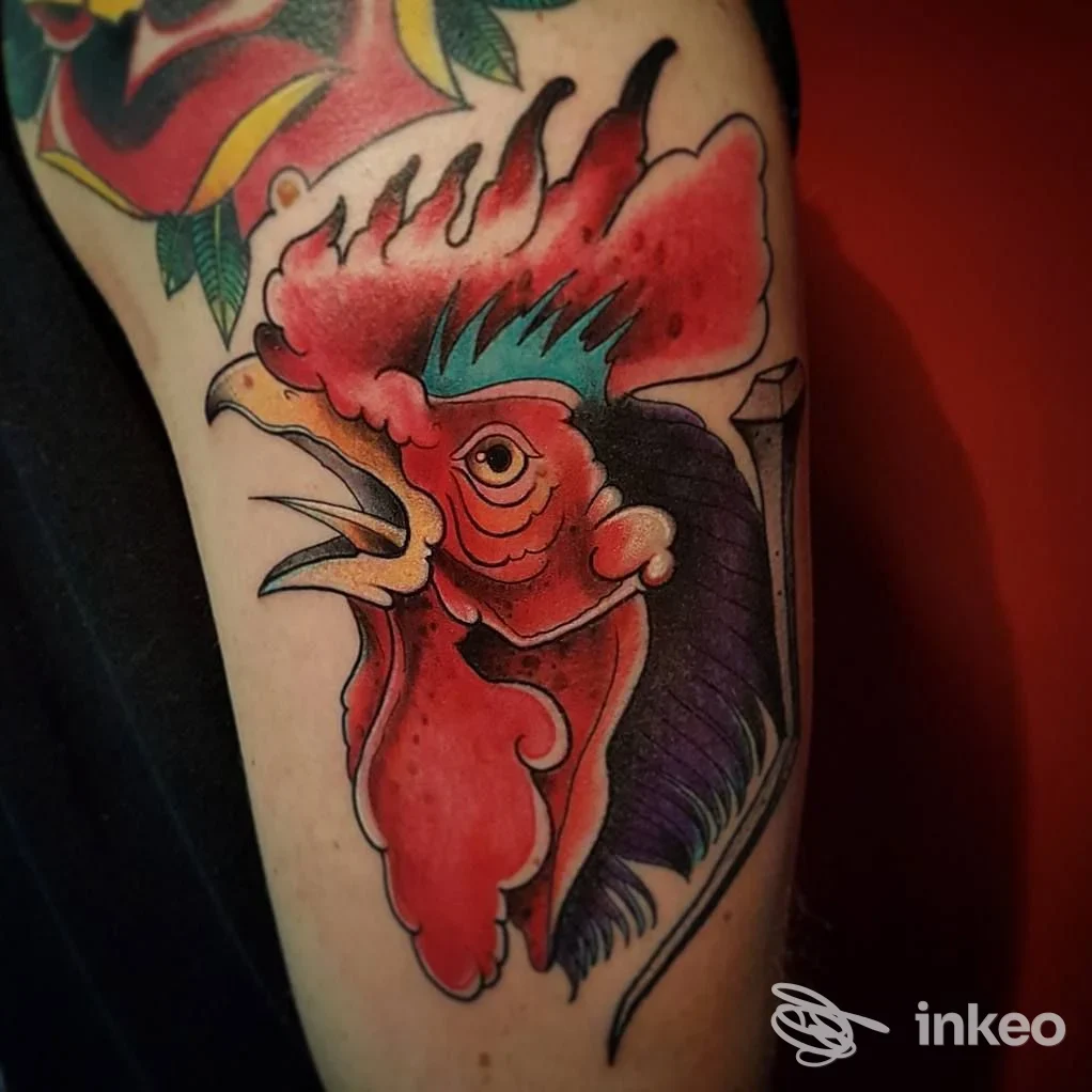 Tatuaggio a colori di una testa di gallo sul braccio superiore, realizzato da Saints & Sinners a Campobasso.