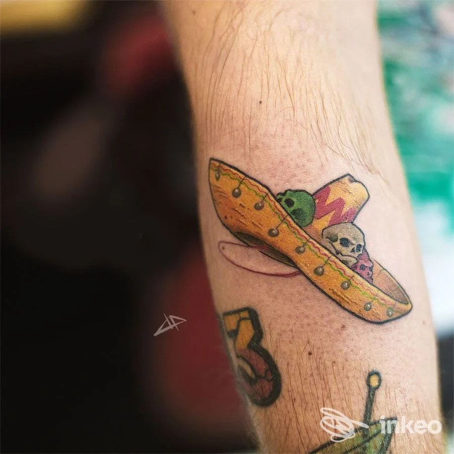 Tatuaggio a colori su avambraccio con piccolo sombrero e teschio, foto fornita da LUMOS Tattoo Studio, Torino.