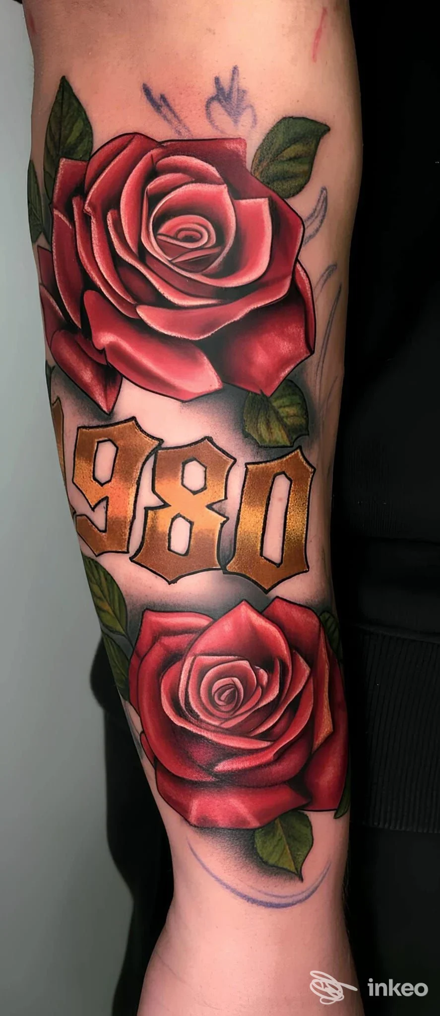 Tatuaggio su avambraccio con due rose rosse e il numero 980, foto fornita da TATTOO BEAUTY SALOON a Condove.