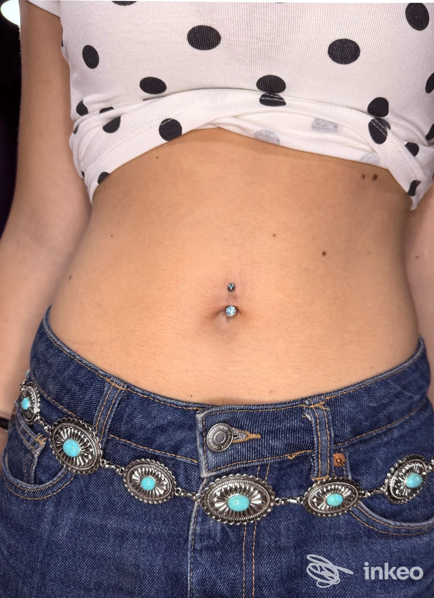 Piercing all'ombelico fotografato su torso con jeans, immagine per FOX-INKASTONATO a Senigallia.