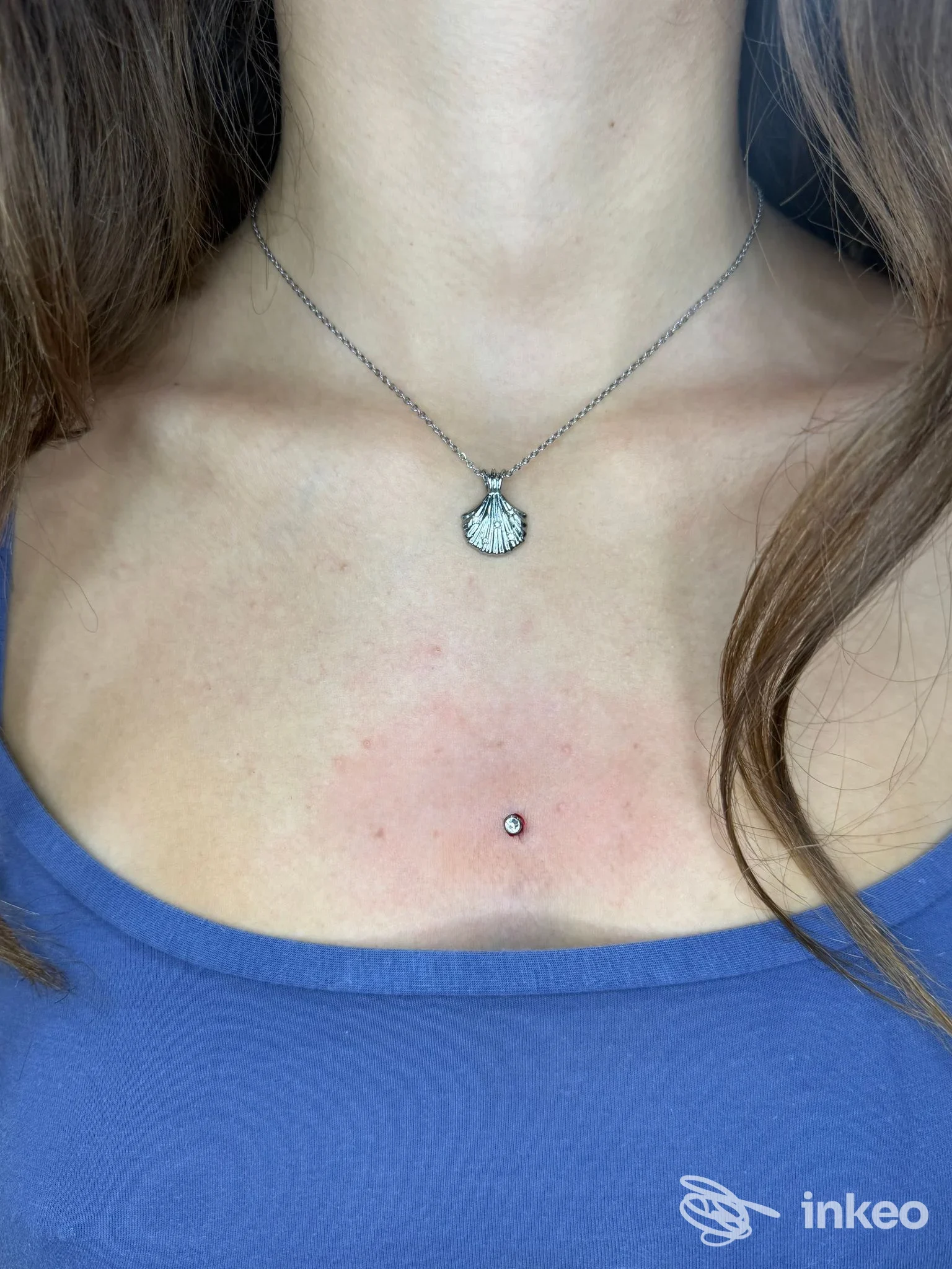 Microdermal/piercing centrale sullo sterno su pelle leggermente arrossata, foto inviata da FOX-INKASTONATO, Senigallia.