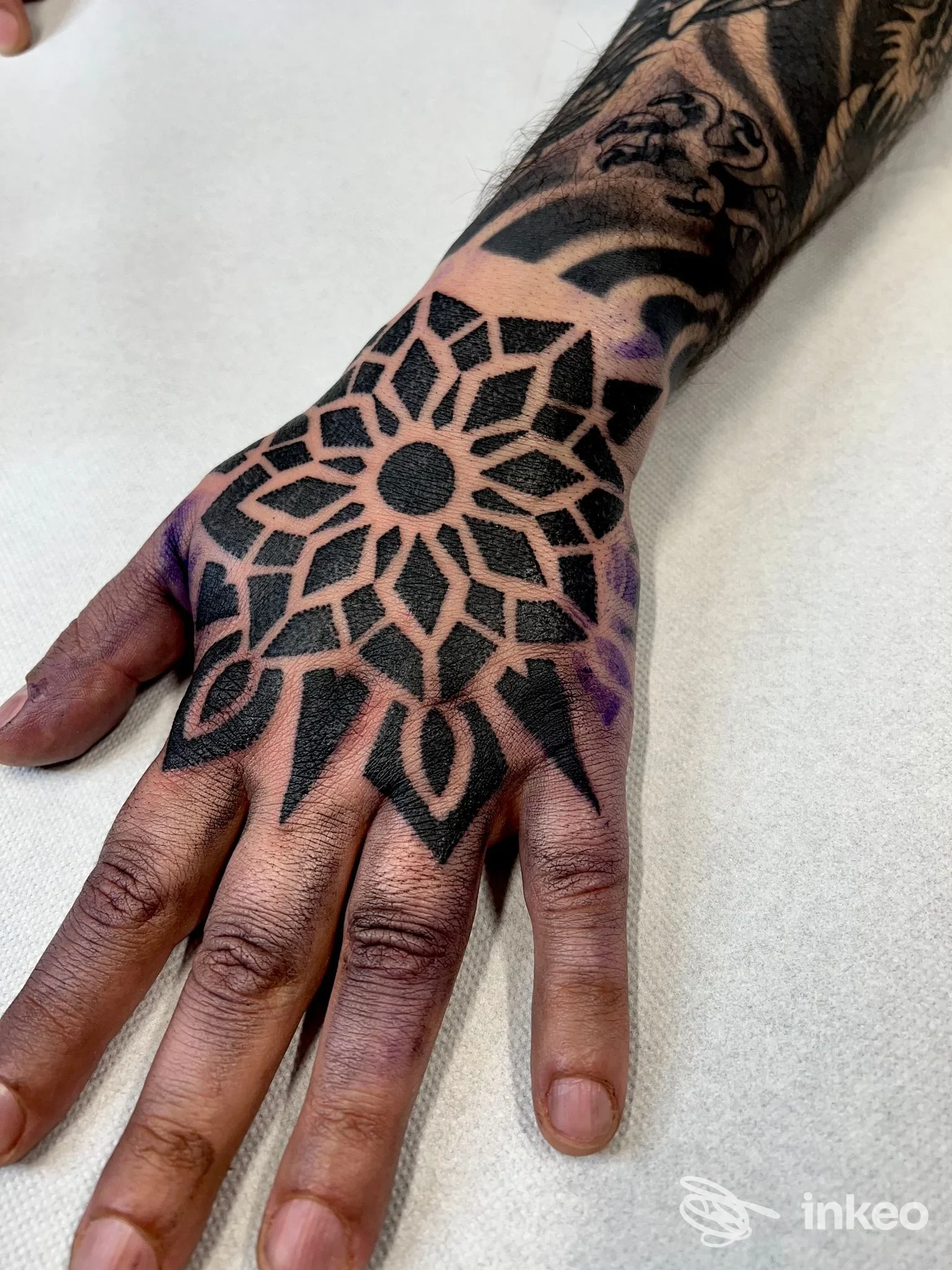 Tatuaggio geometrico blackwork sul dorso della mano, eseguito da Mental Cage Tattoo di Omar Mameli a San Gavino Monreale.