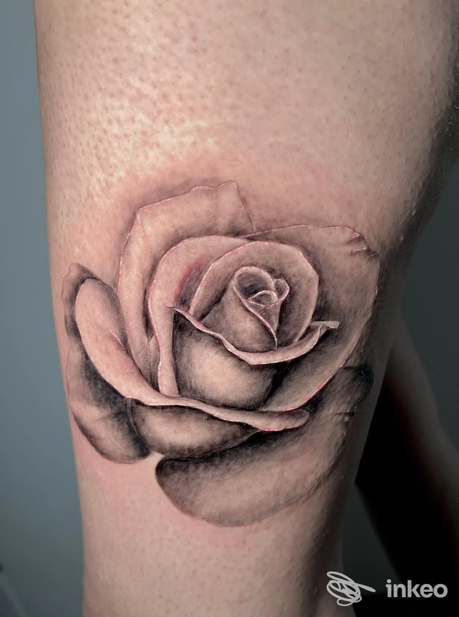 Rosa nera e grigia tatuata sulla coscia, opera di Mental Cage Tattoo a San Gavino Monreale.