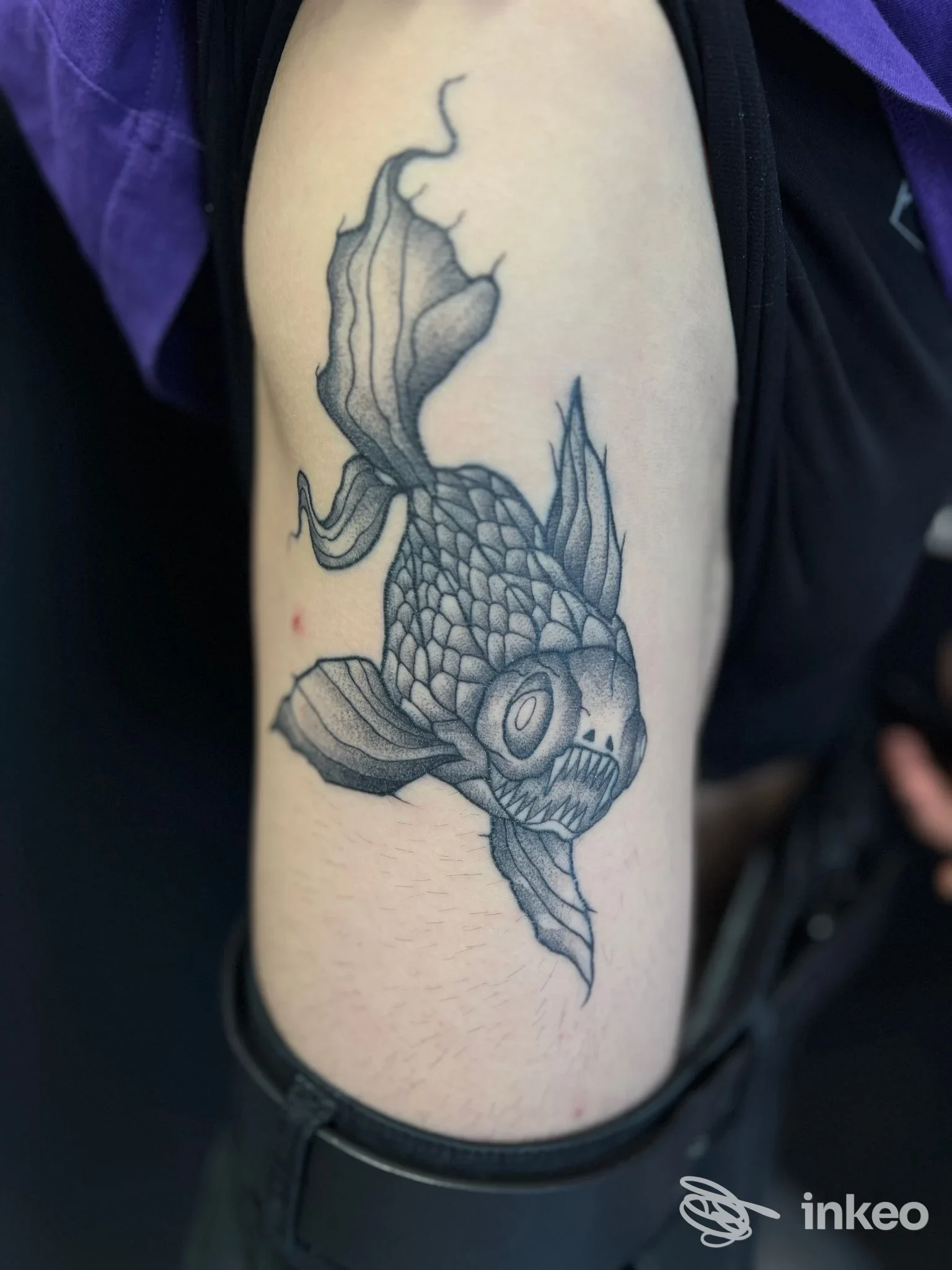 Tatuaggio black & grey di un pesce koi sul bicipite interno, Mental Cage Tattoo, San Gavino Monreale.