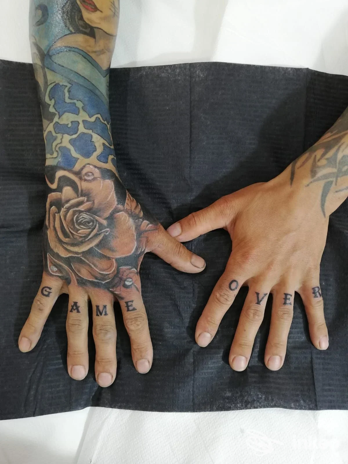 Mani con tatuaggi: scritta 'GAME OVER' sulle nocche e grande rosa sul dorso. Foto di Fabulous Art. TATTOO PIERCING & NAILS di LUANA PURITA' a Grammichele.