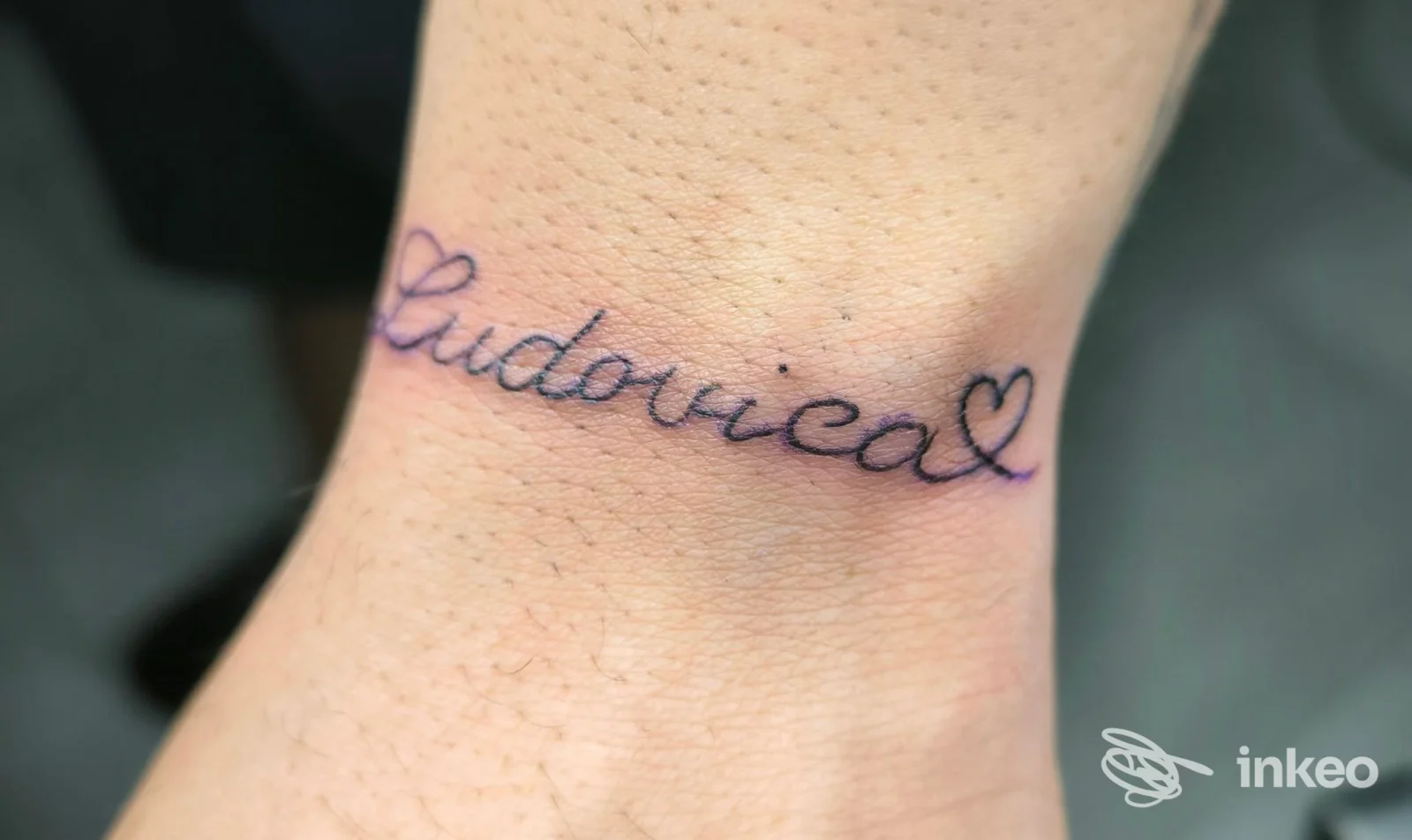 Tatuaggio in corsivo con la scritta "Ludovica" e due cuori sul polso, realizzato dallo studio estetica Sofia tattoo a Modica.