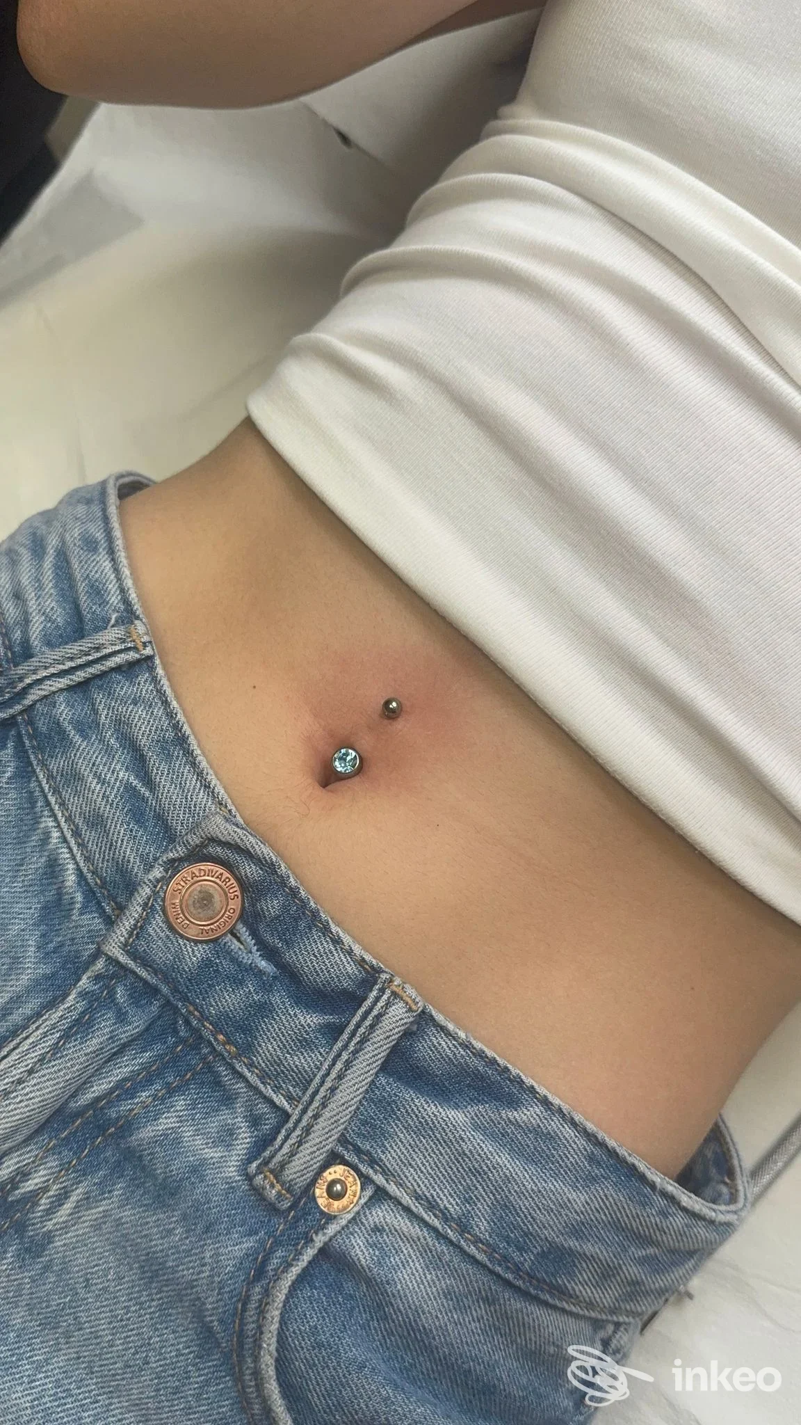 Piercing ombelicale con gemma azzurra, foto inviata dallo studio DM Derma Beauty Piercing a Porto Torres.