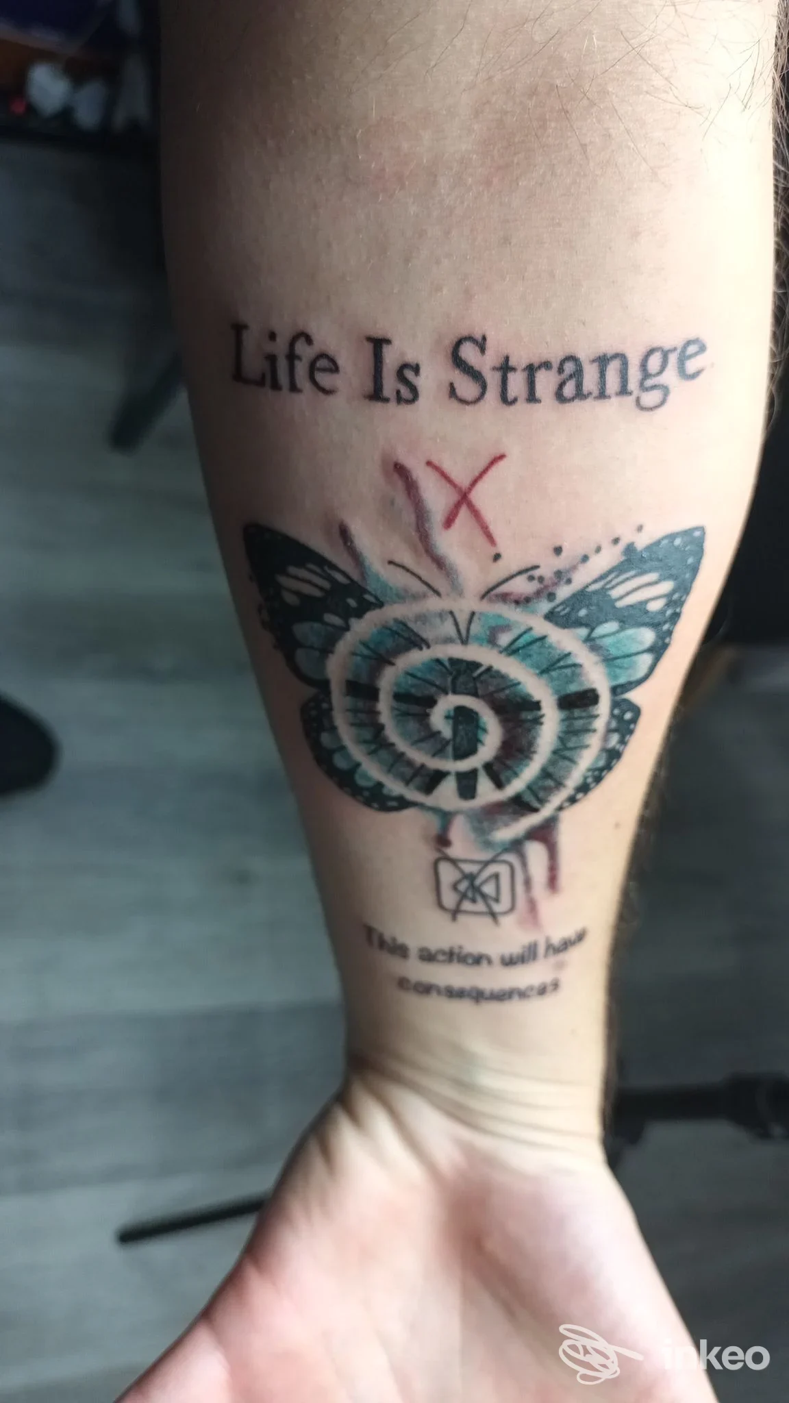 Avambraccio tatuato con la scritta 'Life Is Strange' e un motivo mandala/turquoise; immagine fornita da Marenero tattoo studio, San Teodoro.
