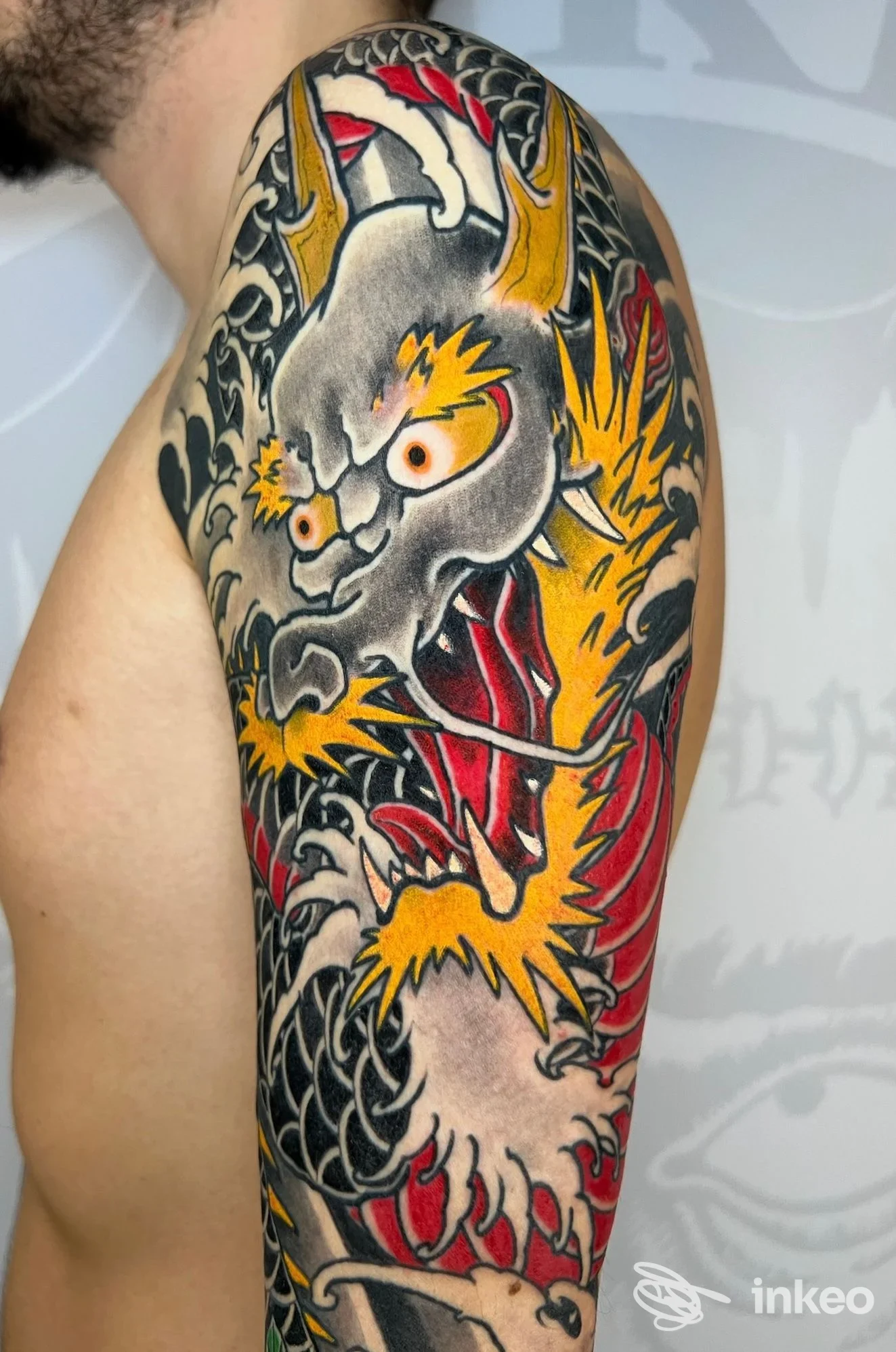Braccio e spalla con ampio tatuaggio a drago colorato; foto del lavoro eseguito da Dr. Frankestein Tattoo a Scandicci.