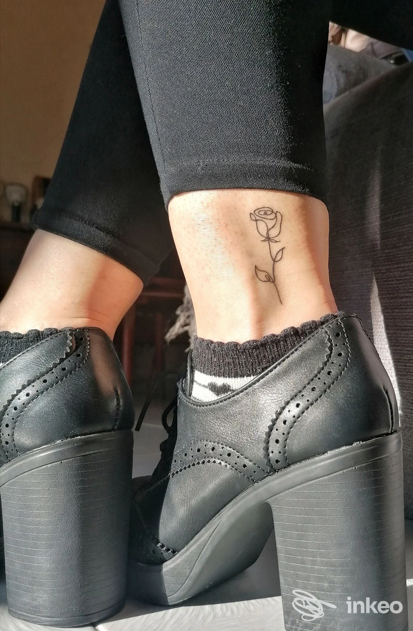 Tatuaggio minimalista a forma di rosa sulla caviglia interna, fotografia per Micaela De Carli Tattoo a Olbia.