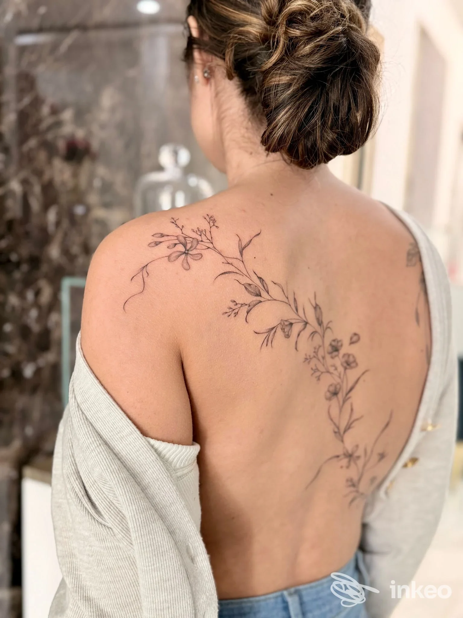 Tatuaggio floreale linework che percorre la scapola e la colonna della schiena, foto servizio Micaela De Carli Tattoo, Olbia.
