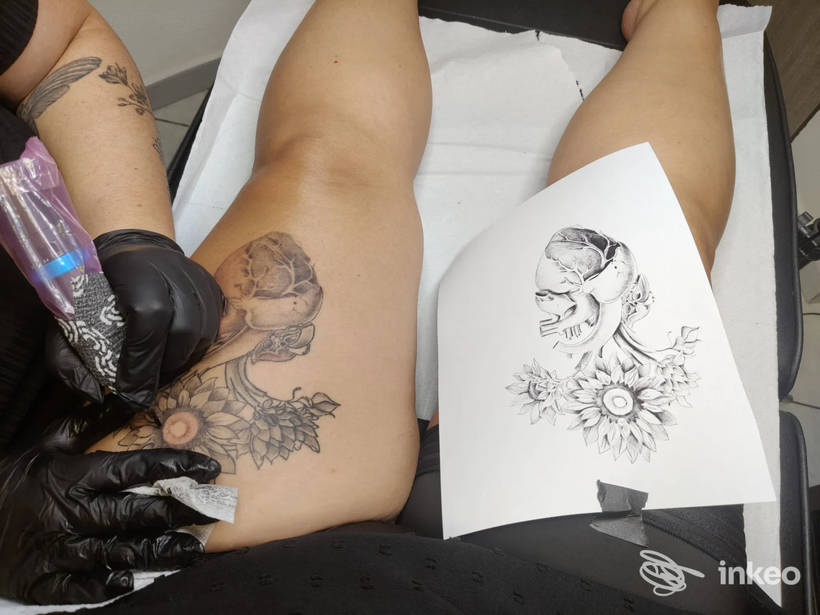 Tatuaggio in corso su coscia con teschio e fiori, foto di Atelier Sardegna beauty and Tattoo center a Sestu.