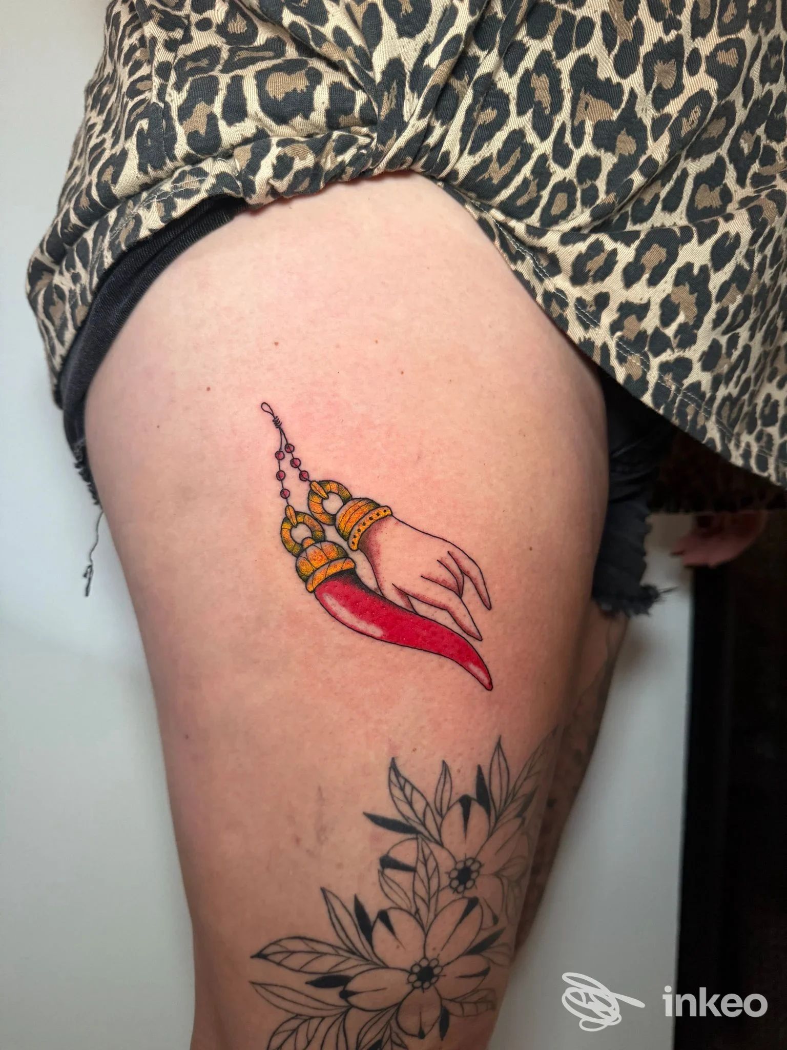 Tatuaggi su coscia con mano decorata e corno rosso, lavoro caricato da Bettie Love Tattoo Studio a Olbia.