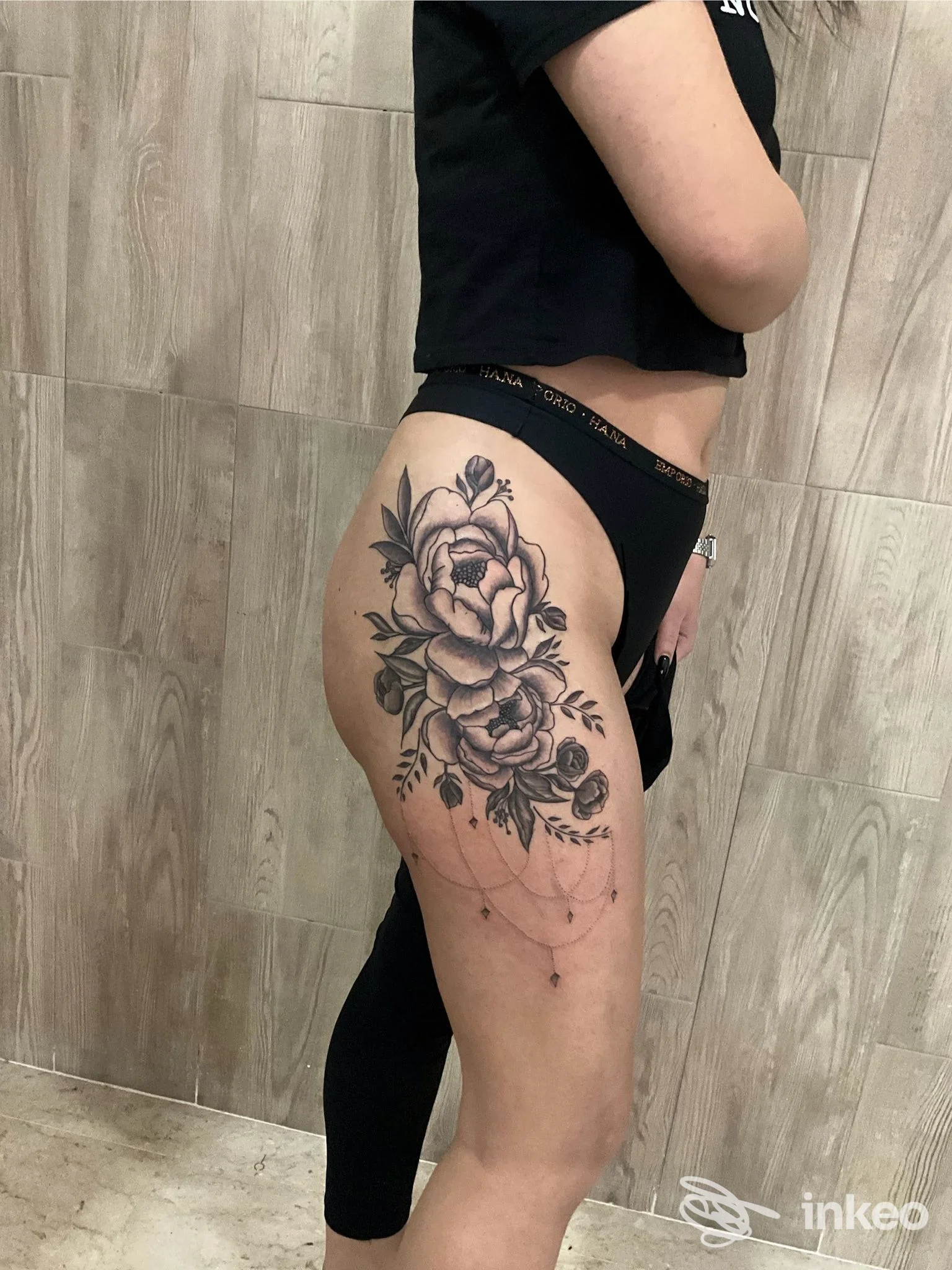 Tatuaggio floreale in bianco e nero sul fianco e sulla coscia, grande composizione ornamentale. Ale Ink, Trappeto.