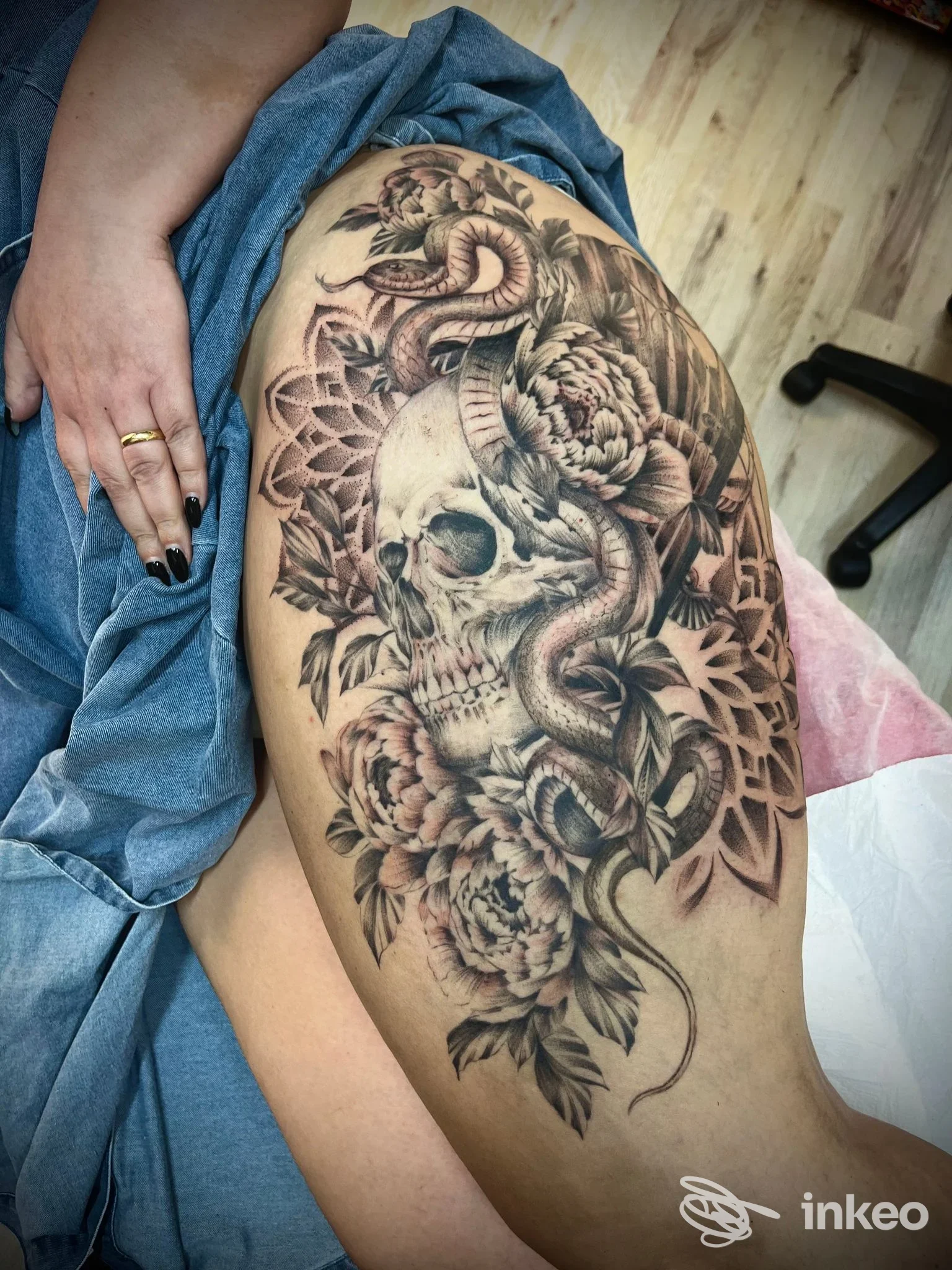 Tatuaggio realistico di teschio, serpente e fiori sulla coscia, foto fornita da Simone Sorano Tattoo & piercing a Messina.