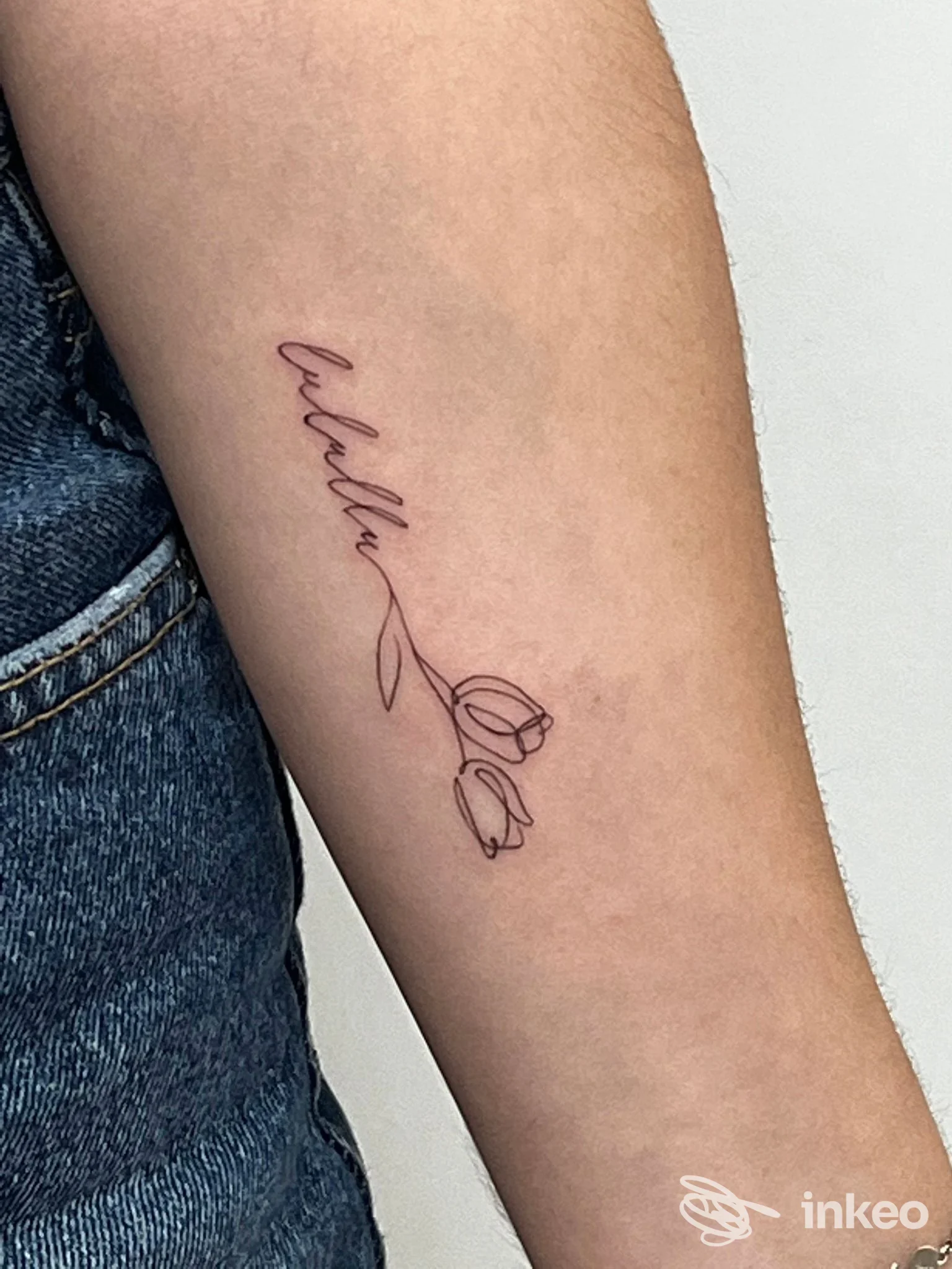 Tatuaggio lineare con due tulipani e scritta sull'avambraccio, lavoro eseguito da Ros’skin Studio a Gela.