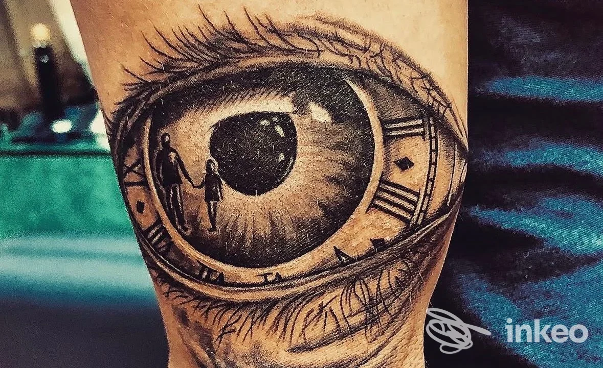 Tatuaggio realistico in bianco e nero di un occhio con orologio e due silhouette sull'avambraccio, realizzato da Ink & Chic Firenze a Firenze.