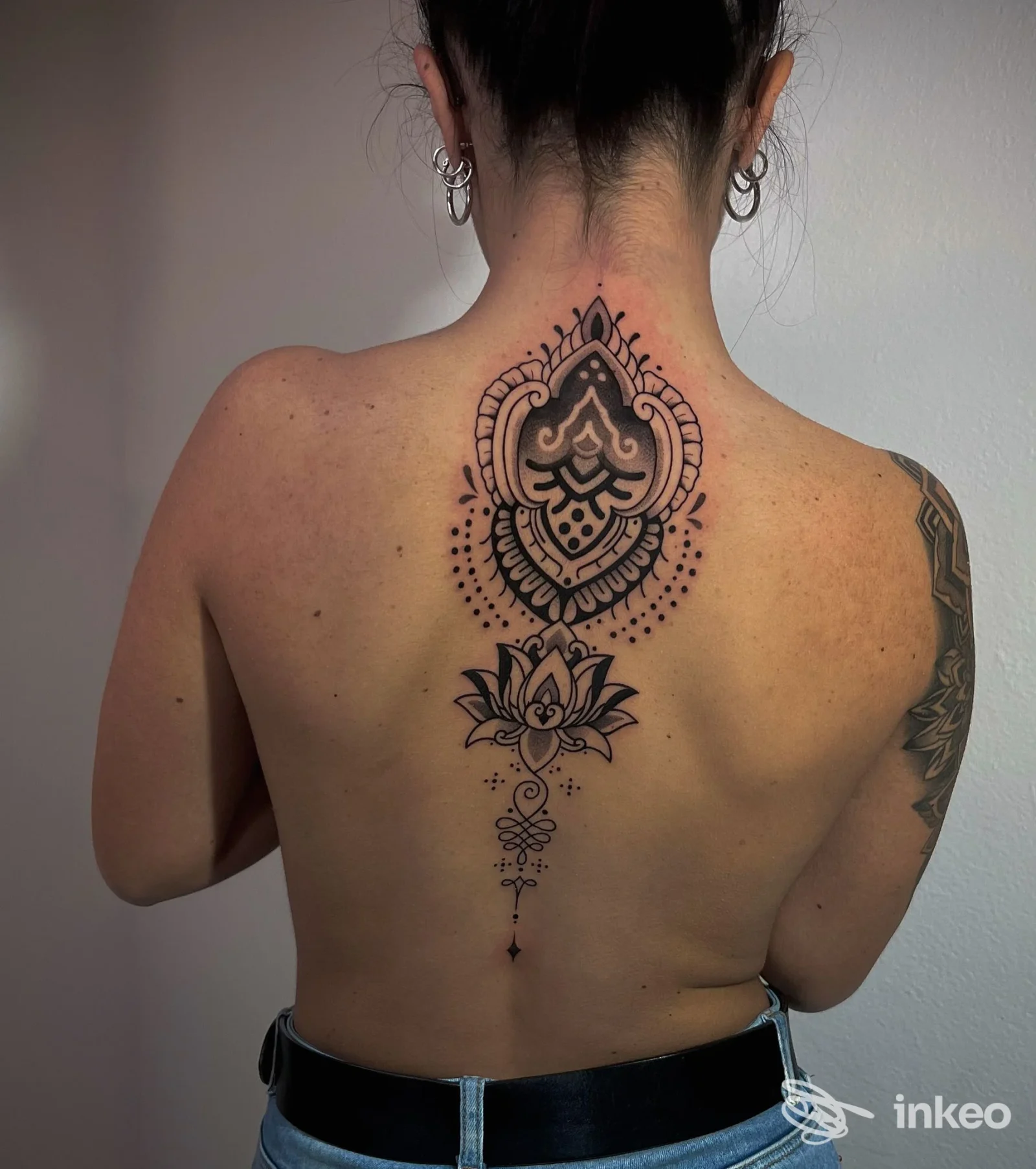 Tatuaggio ornamentale/mandala centrale lungo la colonna vertebrale, foto realizzata per Revolver Tattoo Studio a Oristano.