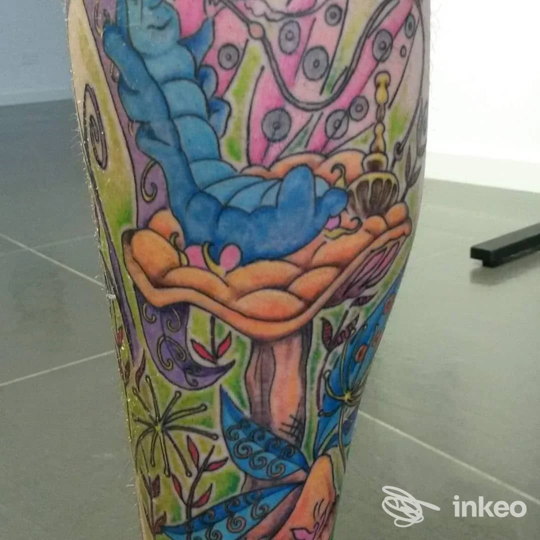 Tatuaggio colorato su gamba, stile vivace con elementi vegetali e forme astratte, nessun volto visibile, luce neutra.