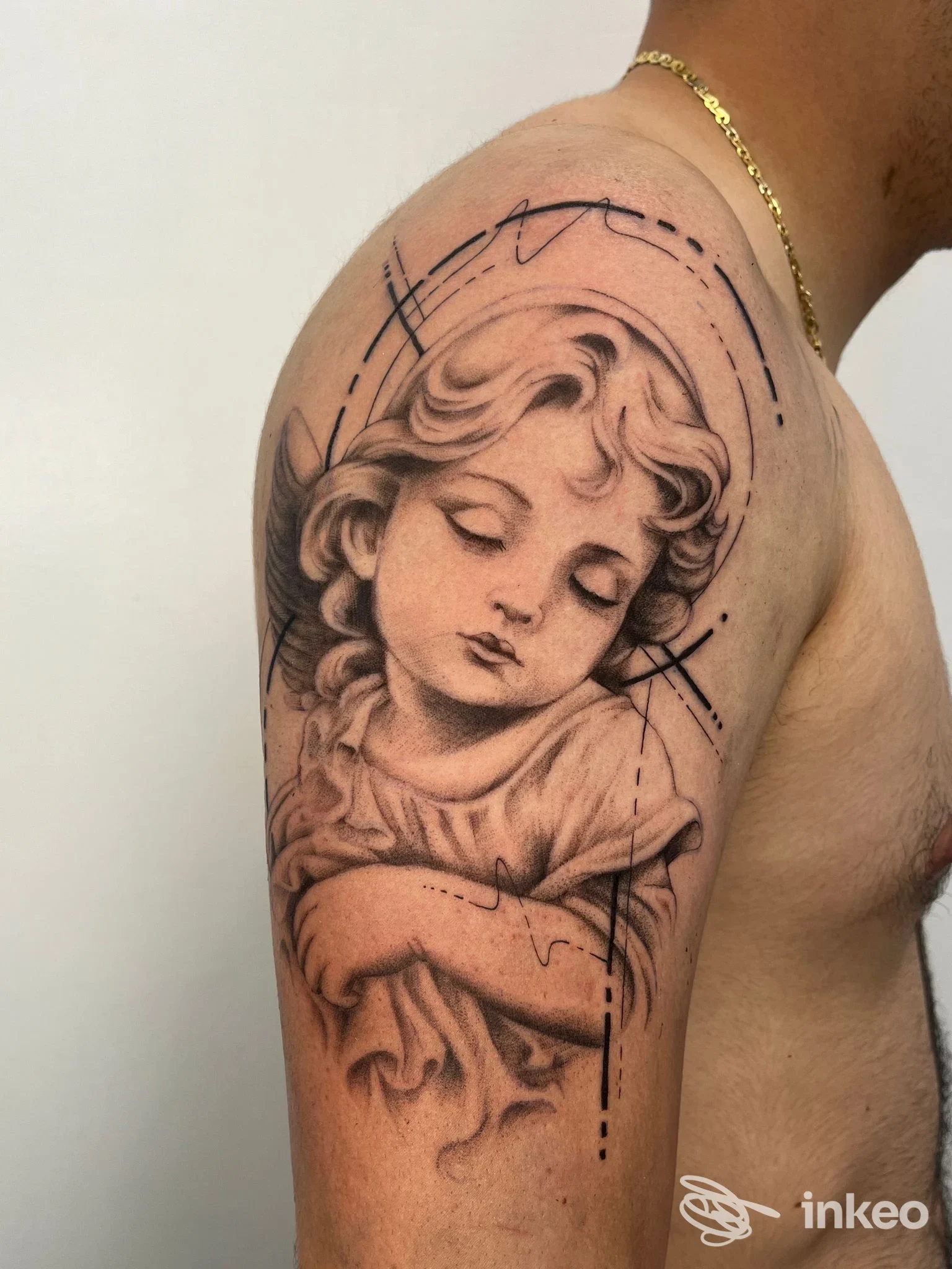 Tatuaggio ritratto in bianco e nero sulla spalla eseguito da Lema Tattoo a Iglesias, dettaglio del deltoide con soggetto angelico.