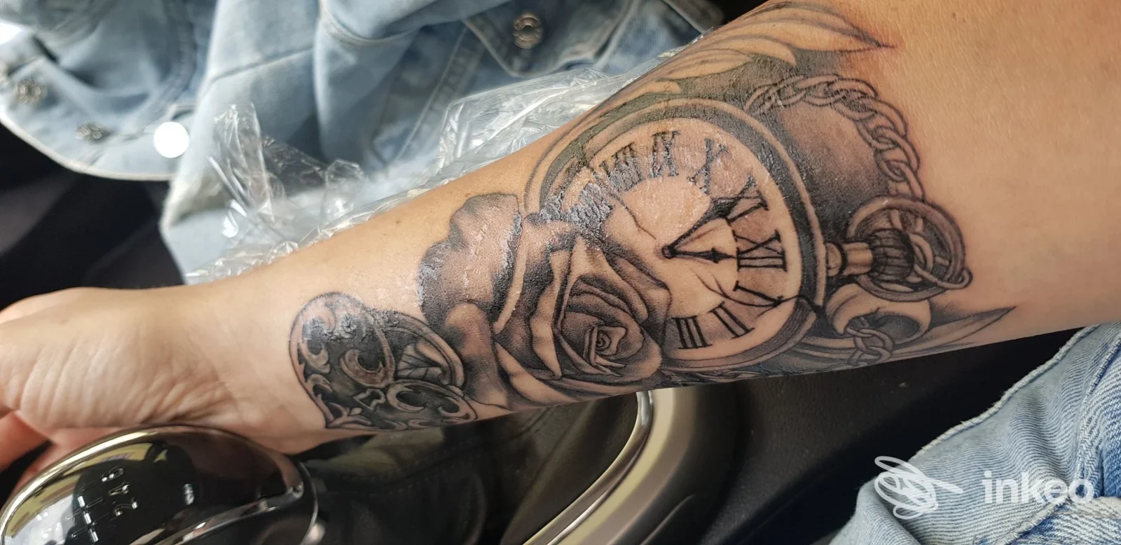 Tatuaggio bianco e nero su avambraccio con orologio a tasca e rose, foto fornita da Tattoo Mirko Pianu a Gonnesa.