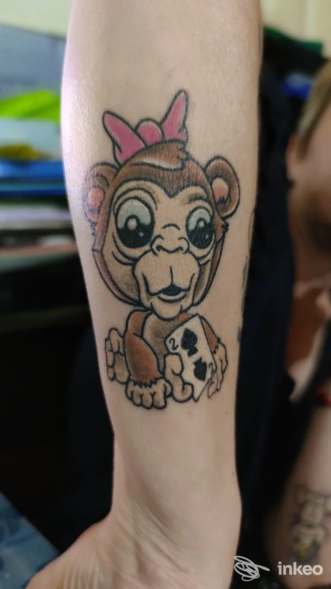 Tatuaggio in stile cartoon raffigurante una scimmia con un fiocco rosa sull'avambraccio, realizzato da Hard Color Tatoo a Massa.