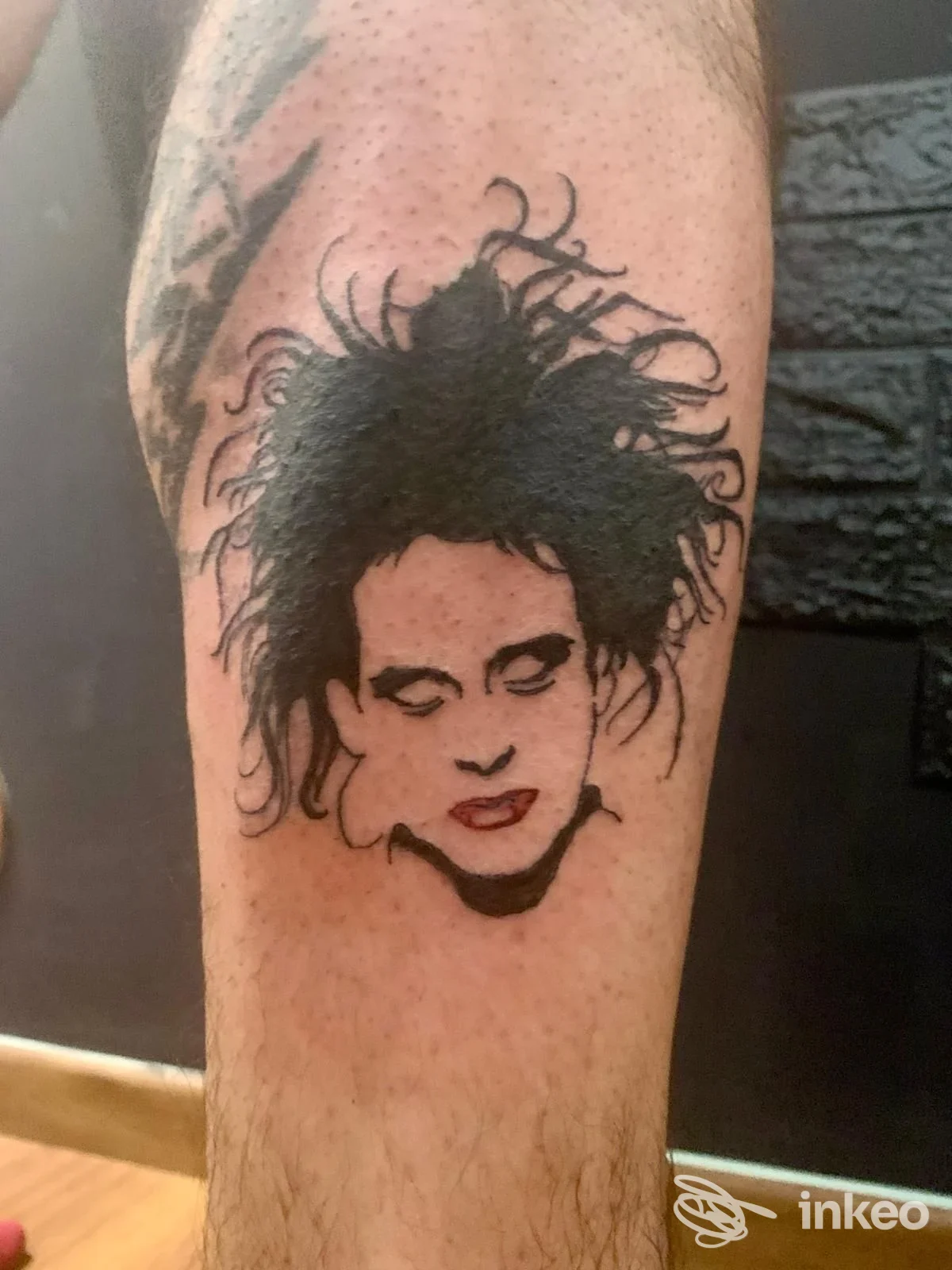 Tatuaggio volto stilizzato in nero sul polpaccio, foto inviata da Eva Ink Black a Bolzano.