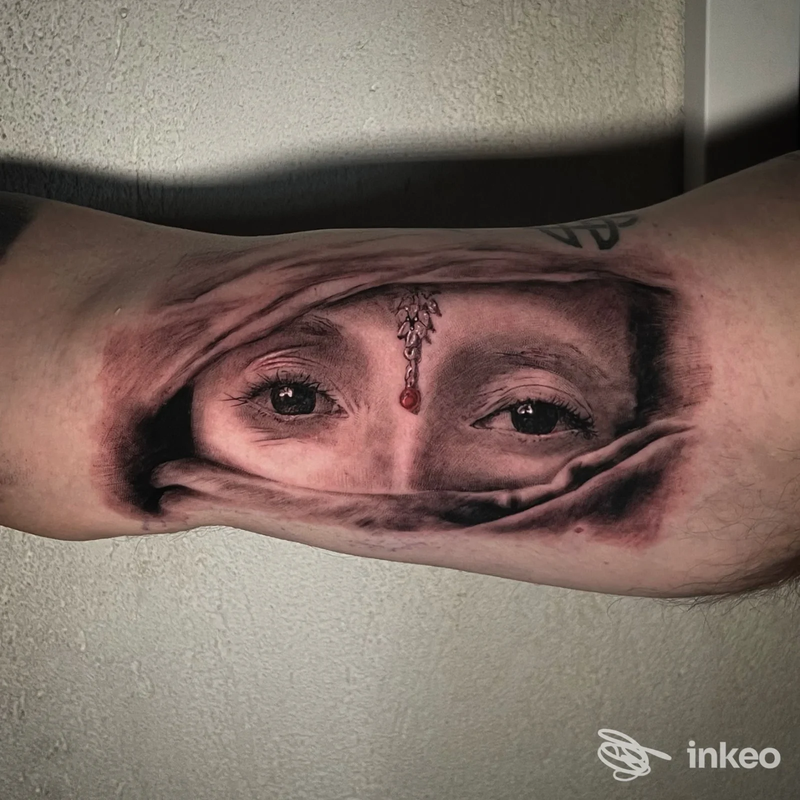 Tatuaggio realistico con occhi e gioiello sull'avambraccio, MRC Tattoo and more, San Bonifacio.
