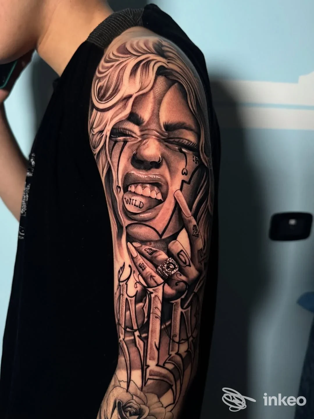 Manica tatuata in bianco e nero con volto realistico e mani sul braccio sinistro, scatto associato a THTINK LAB di Salvatore Ciervo, Riva del Garda.