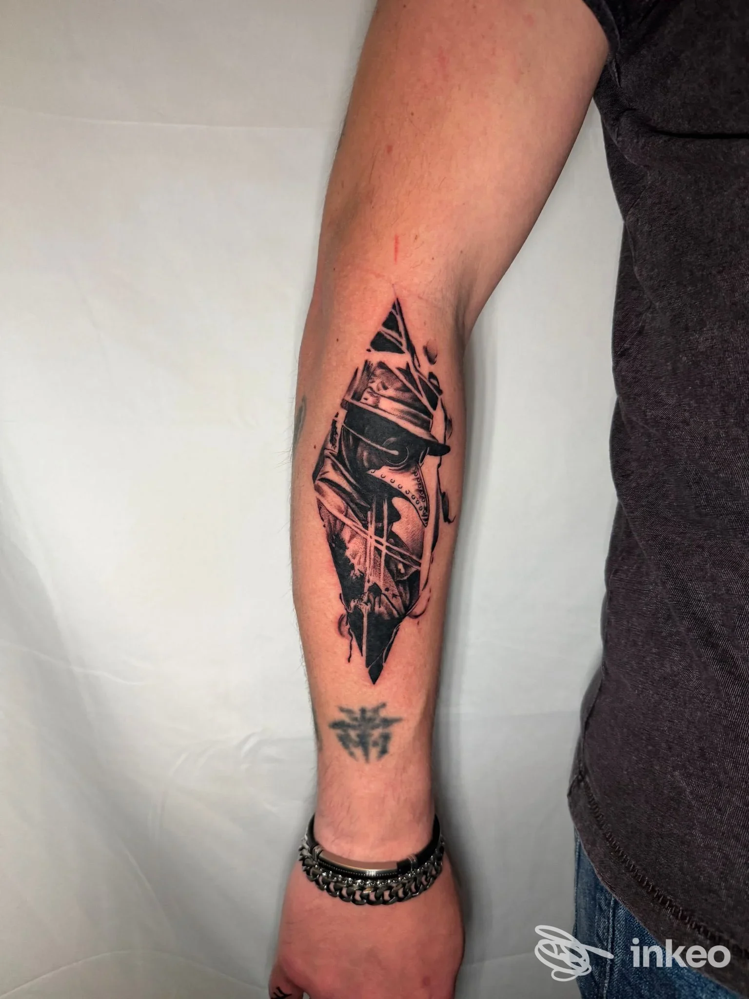 Tatuaggio blackwork realistico sull'avambraccio fotografato per Eternografia, Lucca, inquadratura su pelle e disegno.