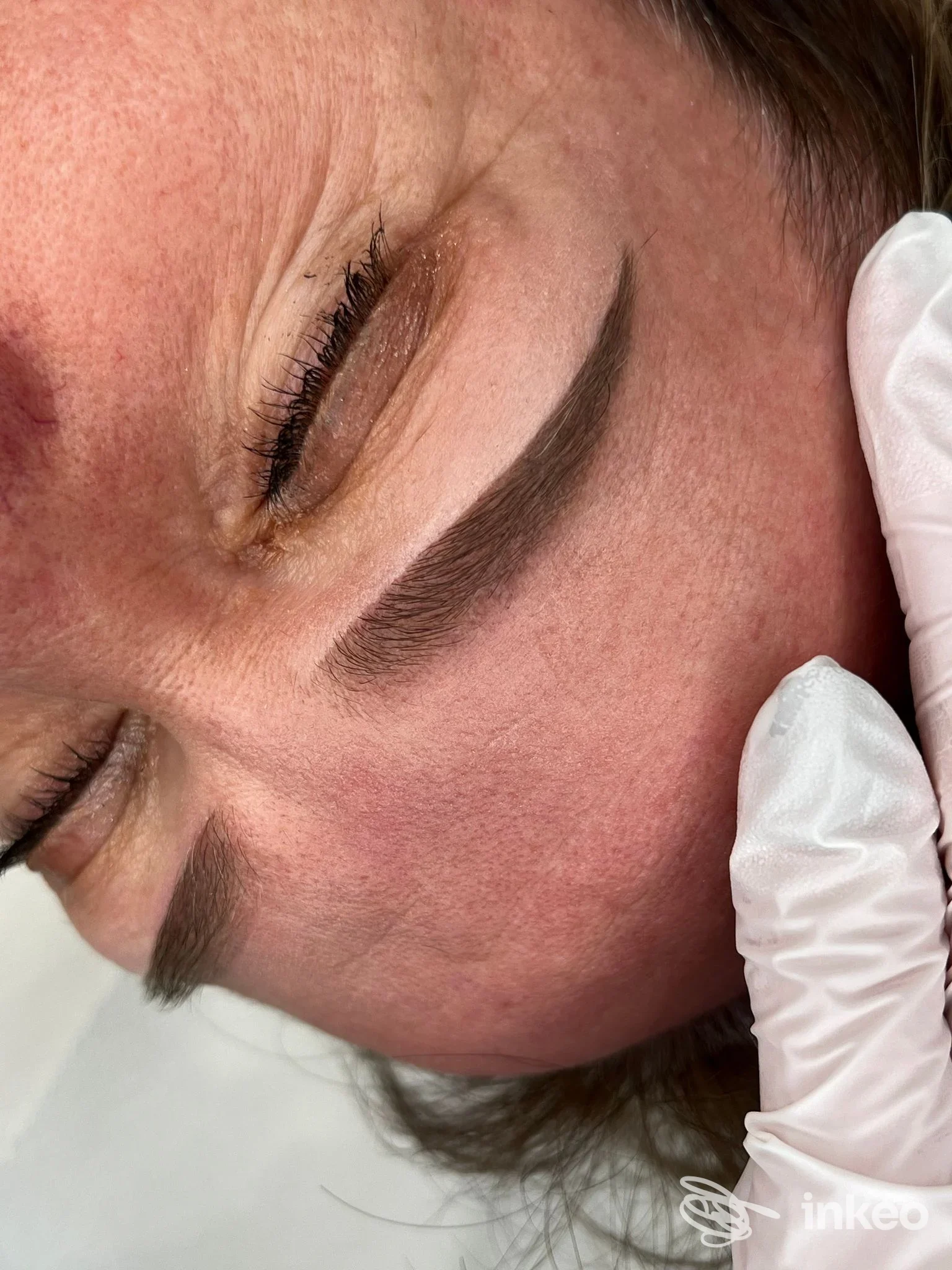 Primo piano di sopracciglio dermopigmentato, mano guantata visibile. Studio Virginia Bellaccini Dermopigmentazione e Skincare, Siena.