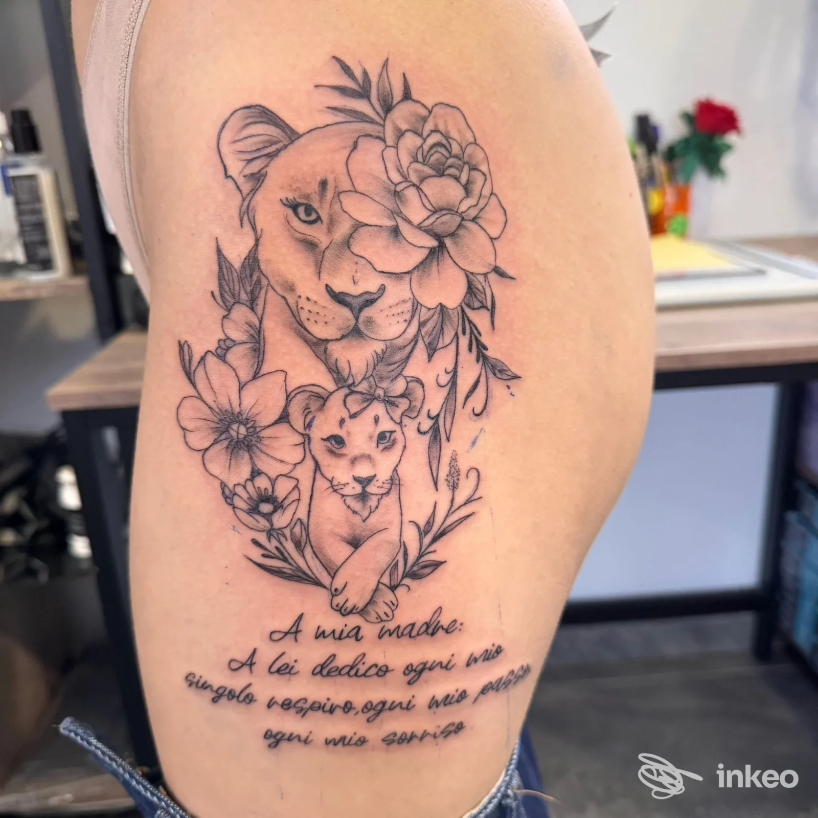 Tatuaggio su braccio con leonessa e cucciolo incorniciati da fiori e scritta, Skin Ink Tattoo and Beauty Potion, Montopoli in Val d'Arno.