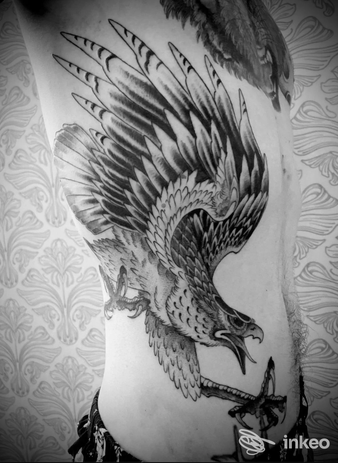 Grande tatuaggio a inchiostro nero di un'aquila sul fianco, foto del lavoro per Royal Fang Ensemble a Bolzano.
