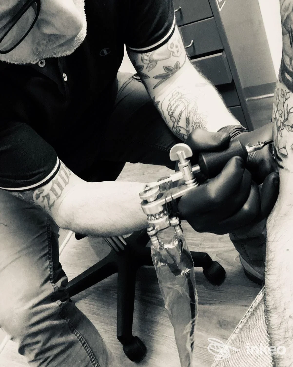 Tatuatore al lavoro sull'avambraccio in bianco e nero, scatto del studio guido tattoo a Cascina.