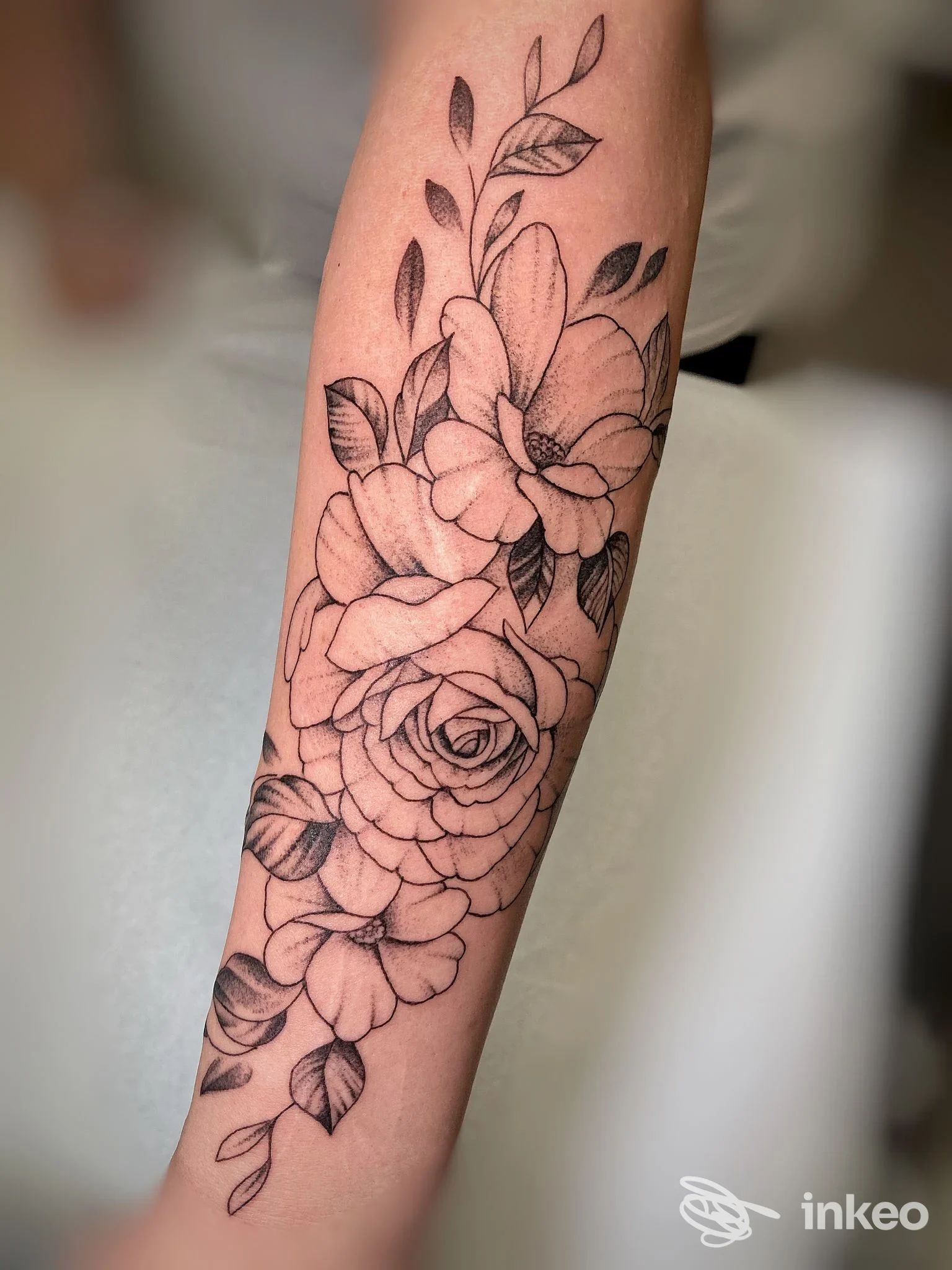 Tatuaggio floreale nero a linee e ombreggiature su avambraccio, foto fornita da guido tattoo, Cascina.