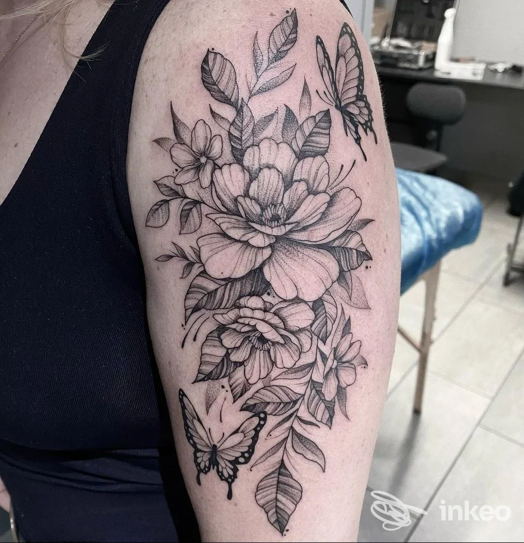 Tatuaggio floreale in bianco e nero con farfalle sul braccio superiore, Needlefactory, Lana.