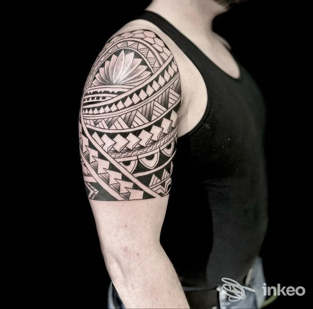 Tatuaggio tribale sulla spalla e bicipite fotografato su soggetto in débardeur, Needlefactory, Lana.
