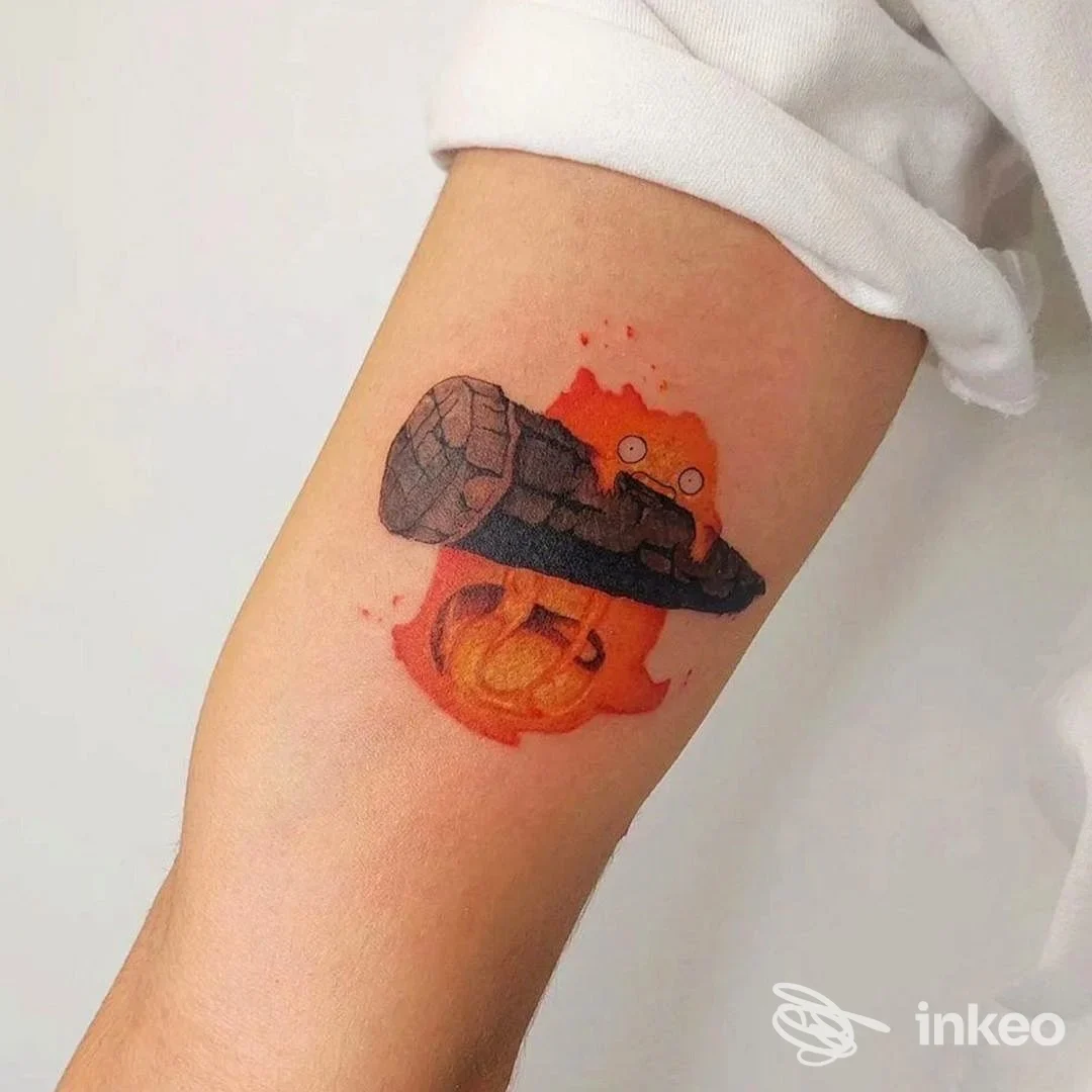 Tatuaggio colorato sull'interno avambraccio: fiamma arancione dietro un ceppo scuro. Sartoria Dell’inchiostro Spinea Blk, Spinea.