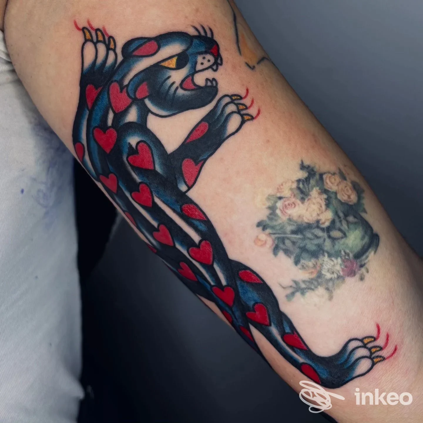 Tatuaggio in stile tradizionale: pantera nera con cuori rossi che corre sull'avambraccio. Voodoo Tattoo Club Padova, Padova.