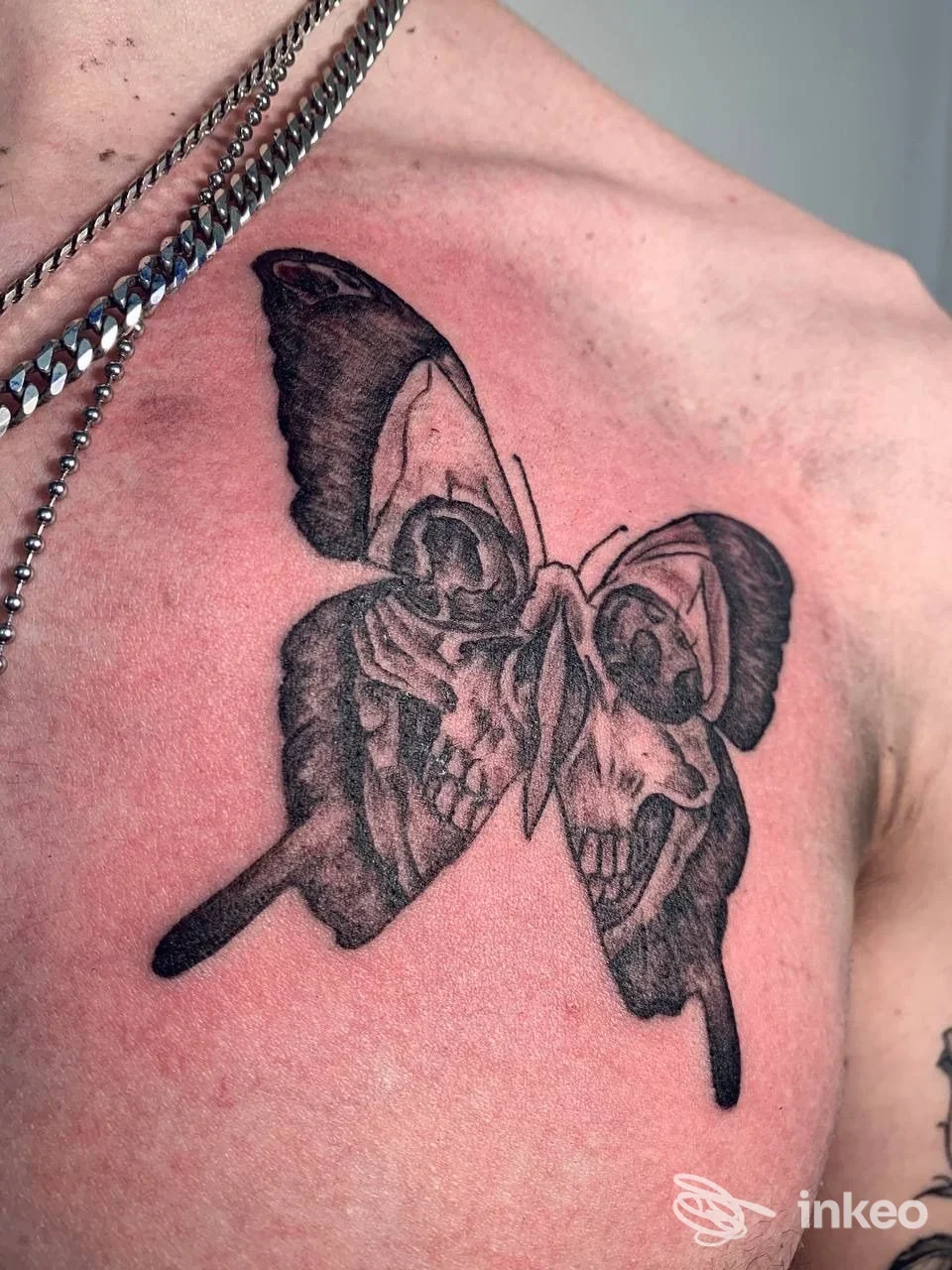 Tatuaggio a forma di farfalla con motivi scheletrici sul petto, scatto in primo piano — VOODOO TATTOO CLUB, Padova.