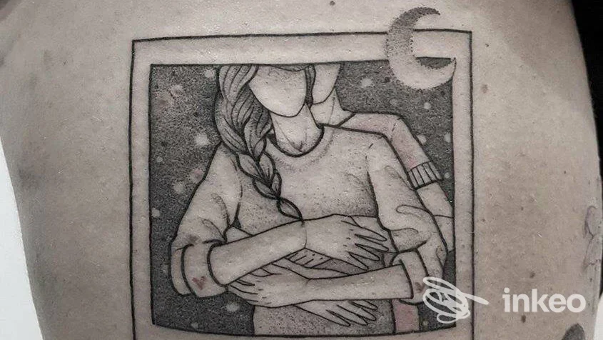 Tattoo grayscale su pelle, frammento di busto con braccia incrociate; nessun volto visibile, solo contorni e shading tipici di un tatuaggio.