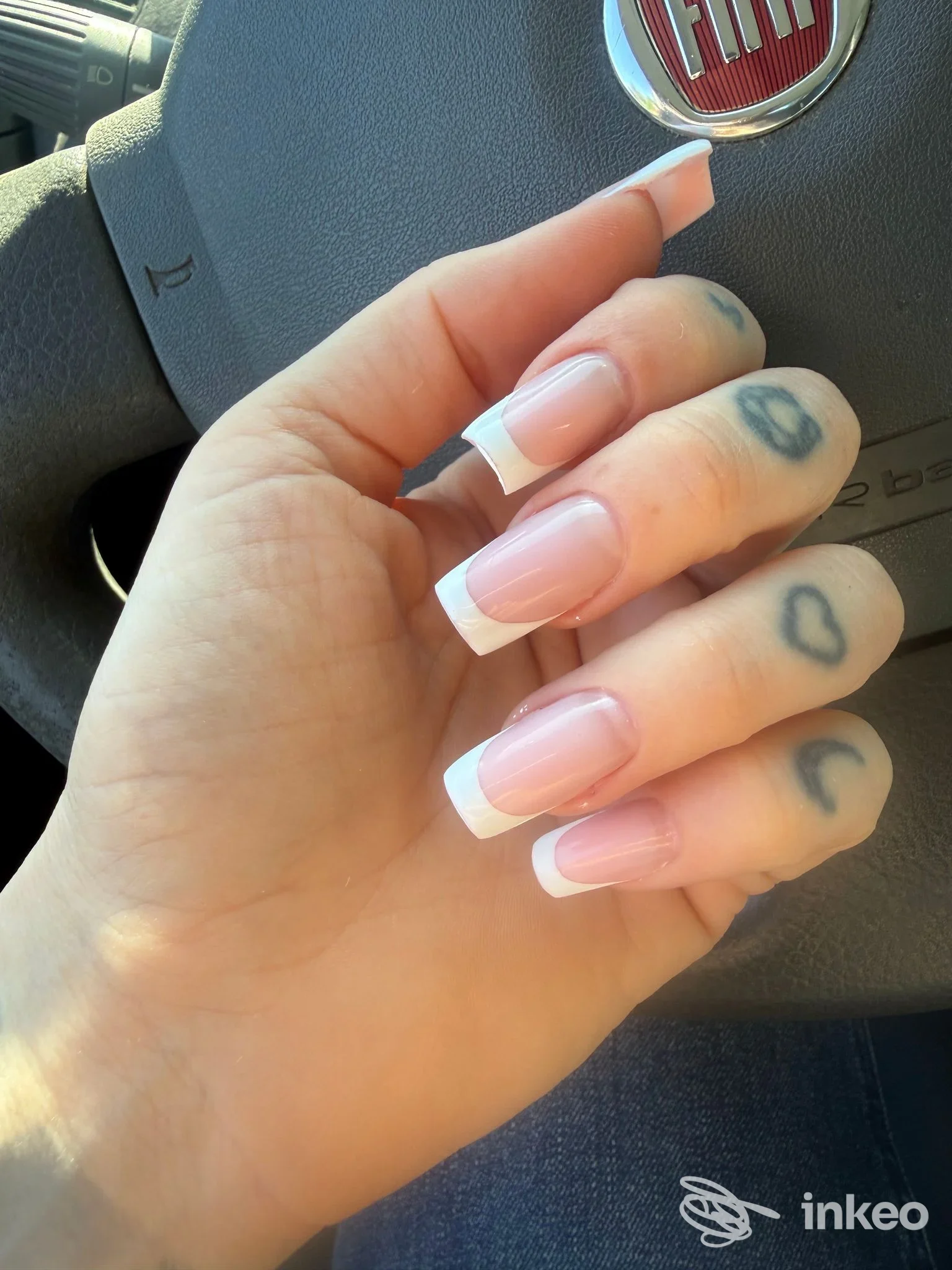 Dettaglio di mano con French manicure e piccoli tatuaggi a cuori sulle dita, immagine fornita da Nails & Beauty di Veronica Saez, Pistoia.