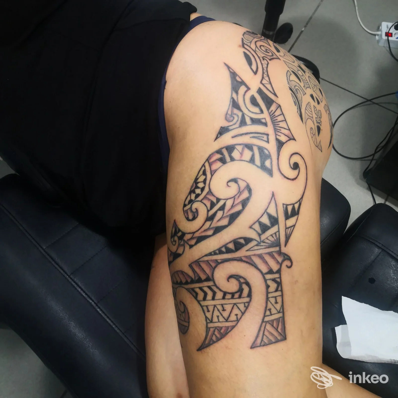 Grande tatuaggio tribale in nero su coscia e fianco, fotografia dallo studio Rose Line Fashion a Treviso.