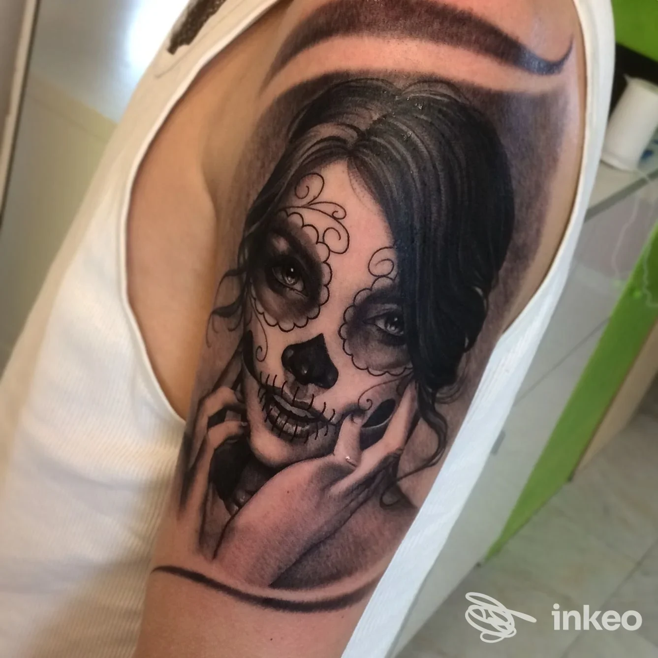 Tatuaggio realistico bianco e nero a tema sugar skull sulla parte superiore del braccio, Bolzano Ink, Bolzano.