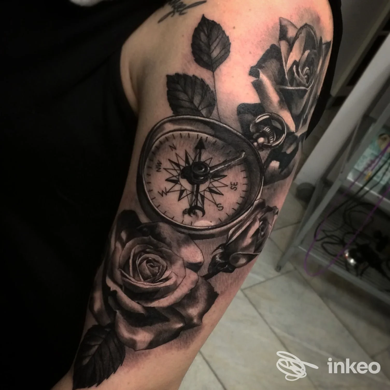 Tatuaggio black & grey di bussola e rose sul braccio, foto proveniente da Bolzano Ink, Bolzano.