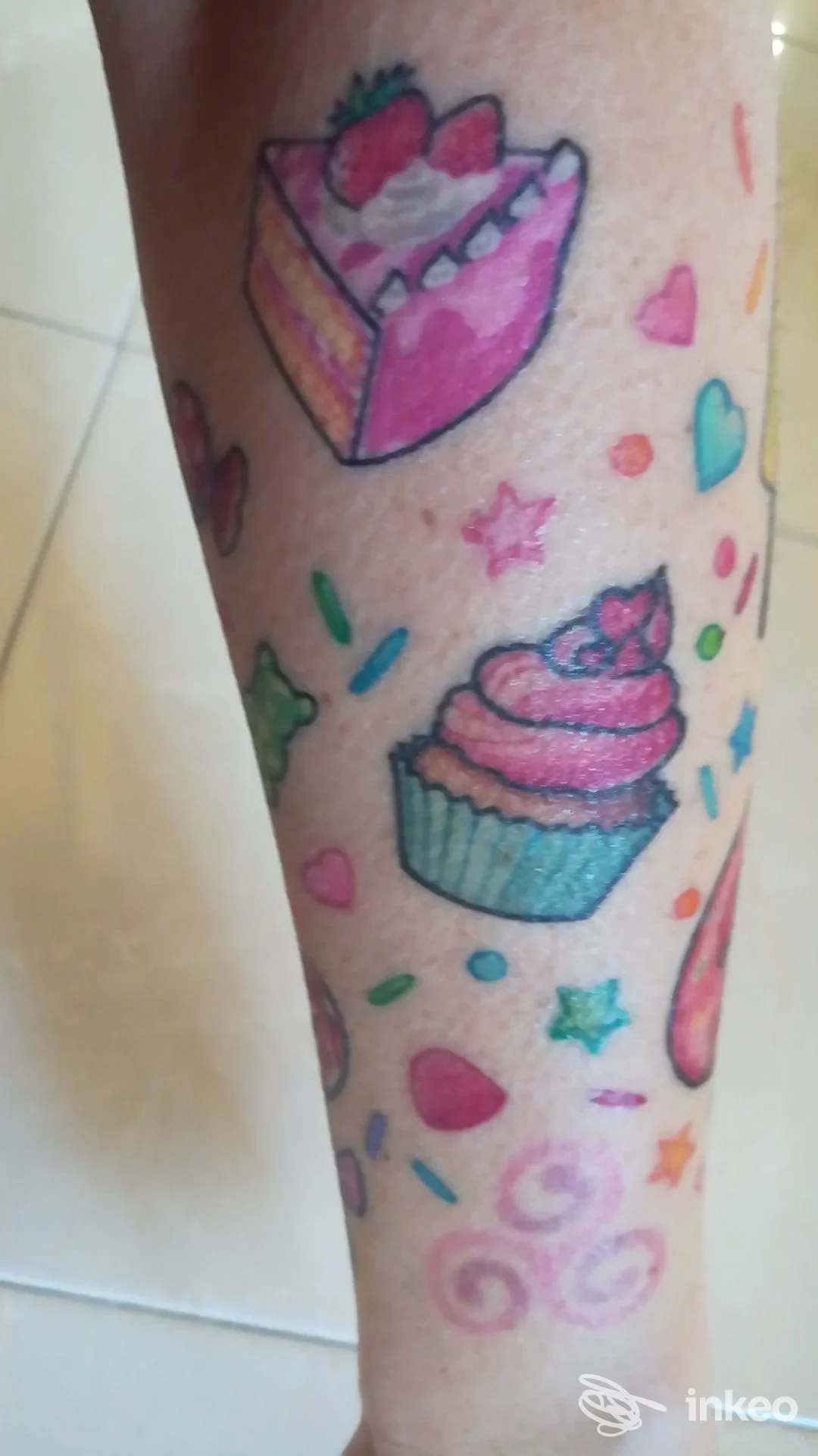 Tatuaggi colorati a tema dolci su avambraccio: cupcake, fetta di torta e decorazioni. Pimp Your Body, Cornedo Vicentino.