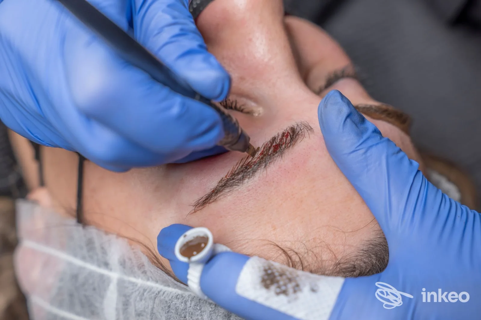 Procedura di dermopigmentazione sopracciglia eseguita presso Valentina Beauty Studio a Verona, dettaglio delle mani dell'operatrice e dell'area trattata.